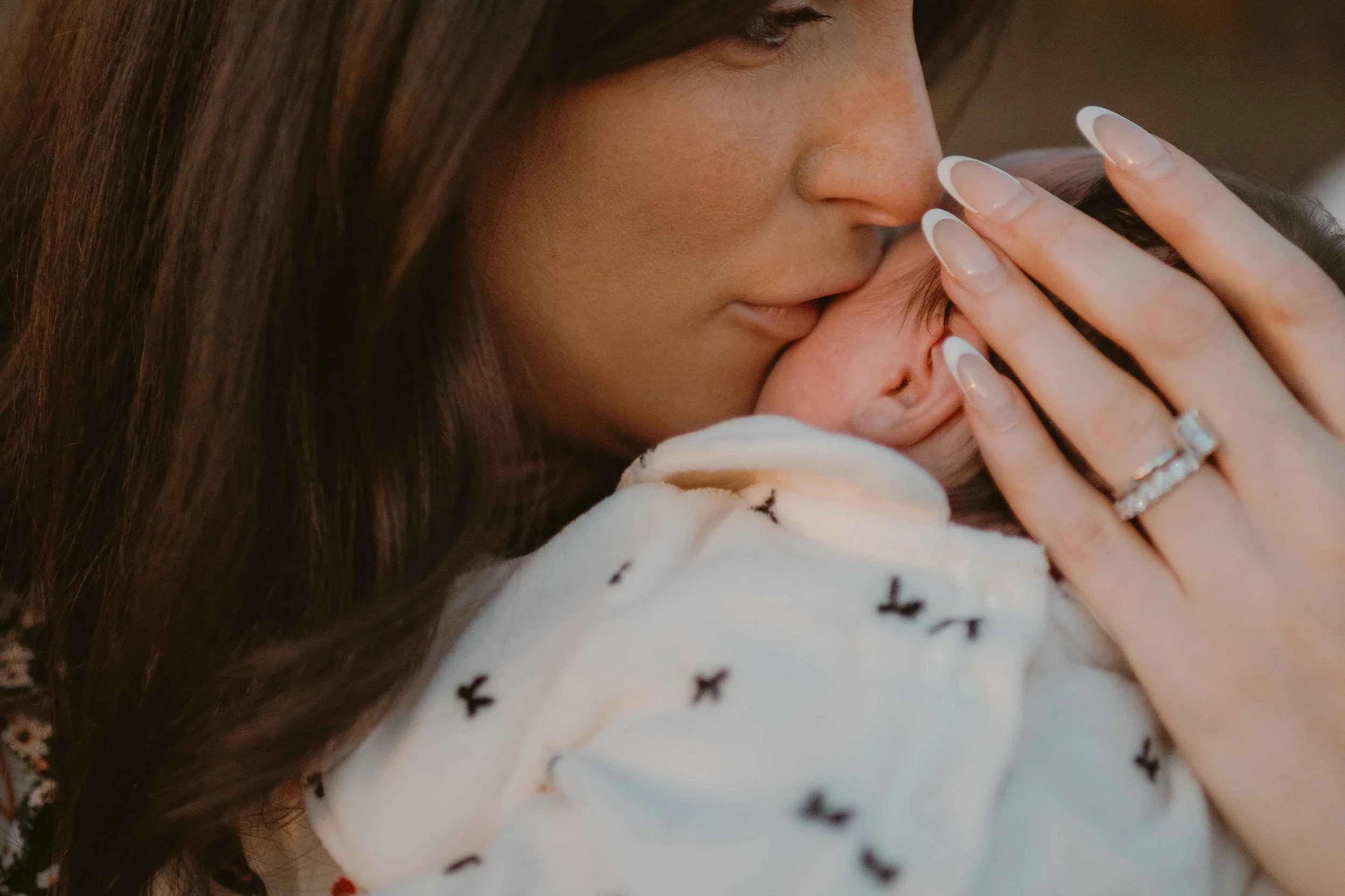 mom kissing new baby head at the Morton Arboretum Lisle IL 