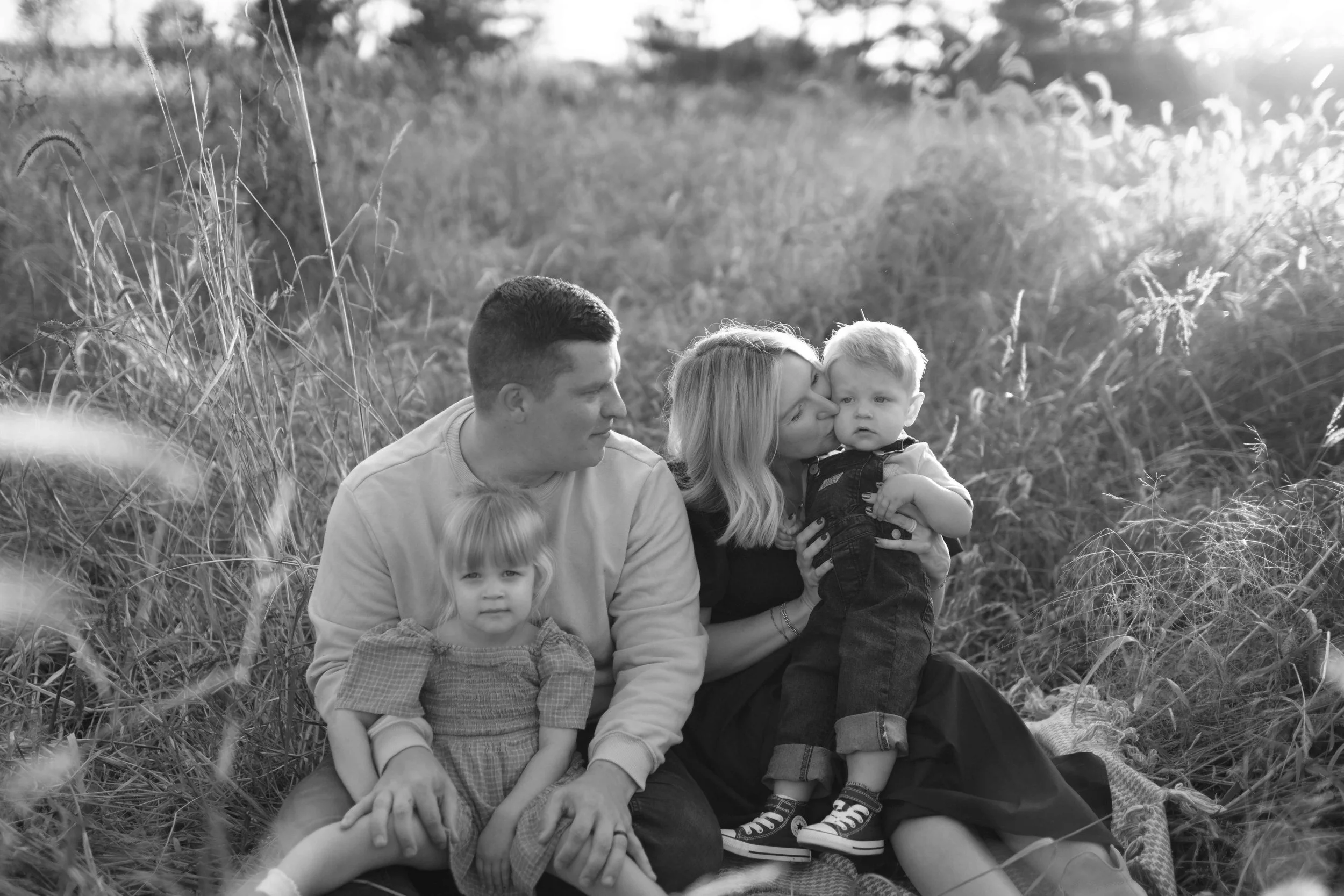 black and white photo of family of four all sitting on blanket at Blackwell Forest Preserve in Wheaton 
