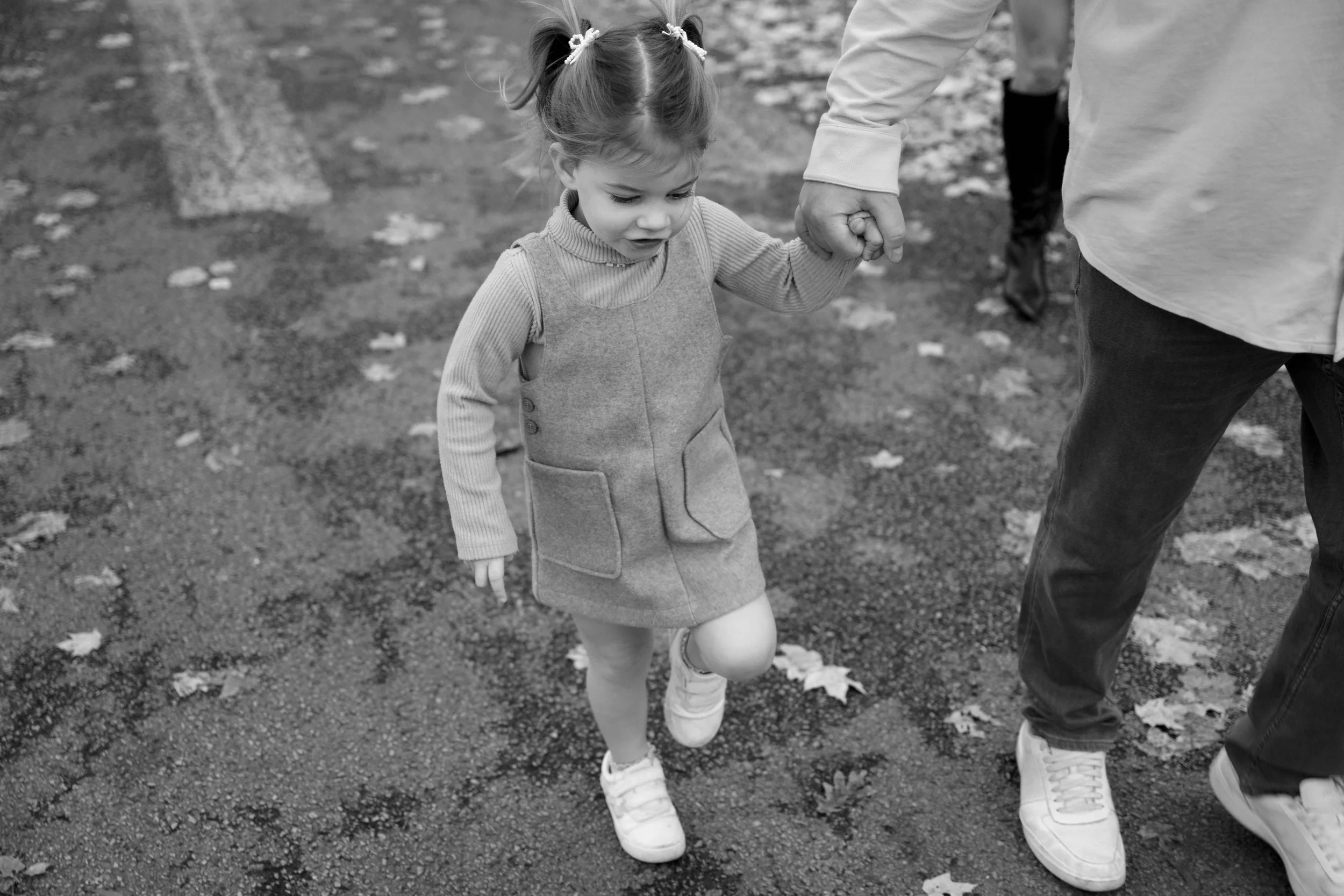 black and white closeup of daughter holding dads hand