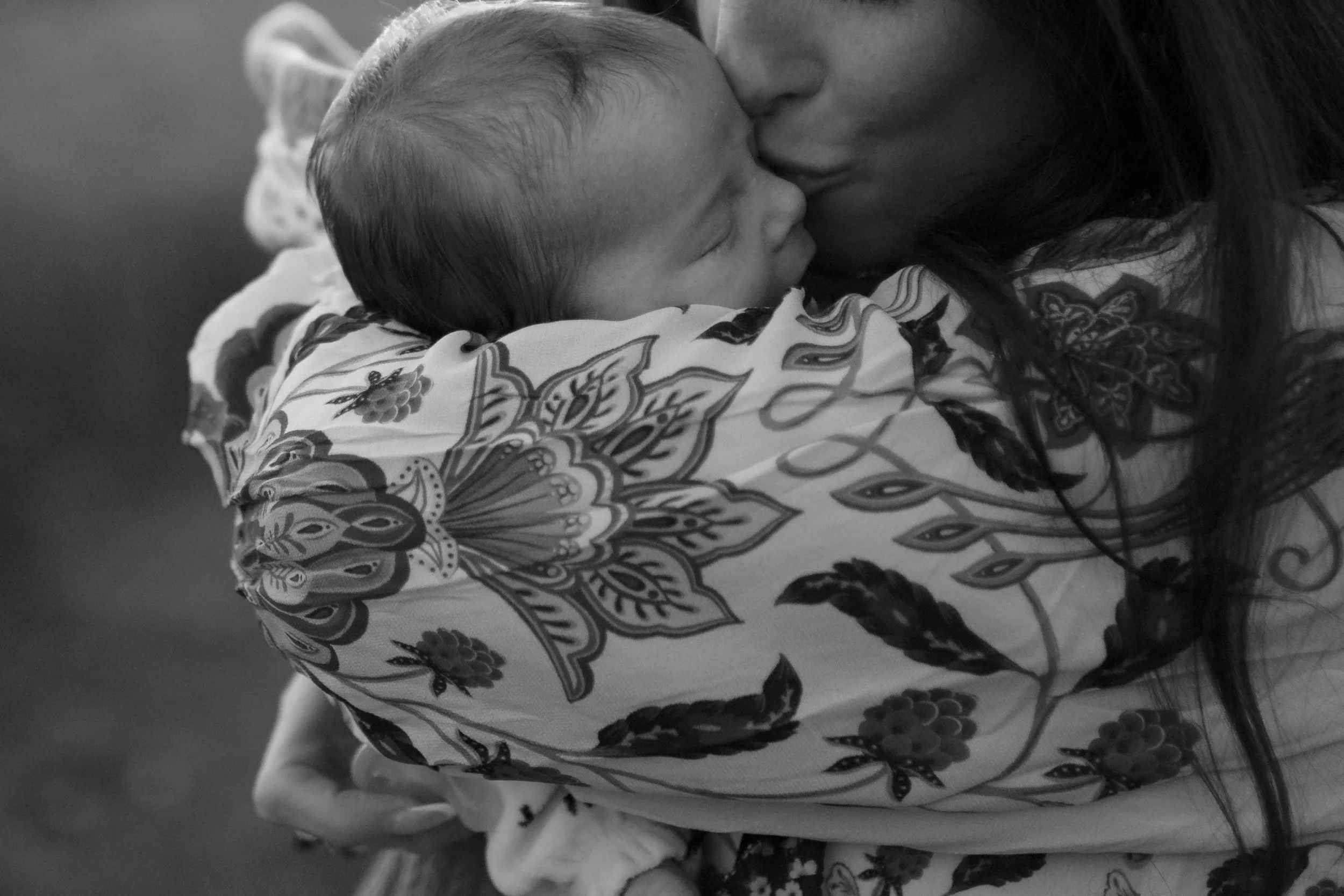 black and white close up of moms lips kissing new baby head at Morton Arboretum Lisle IL 