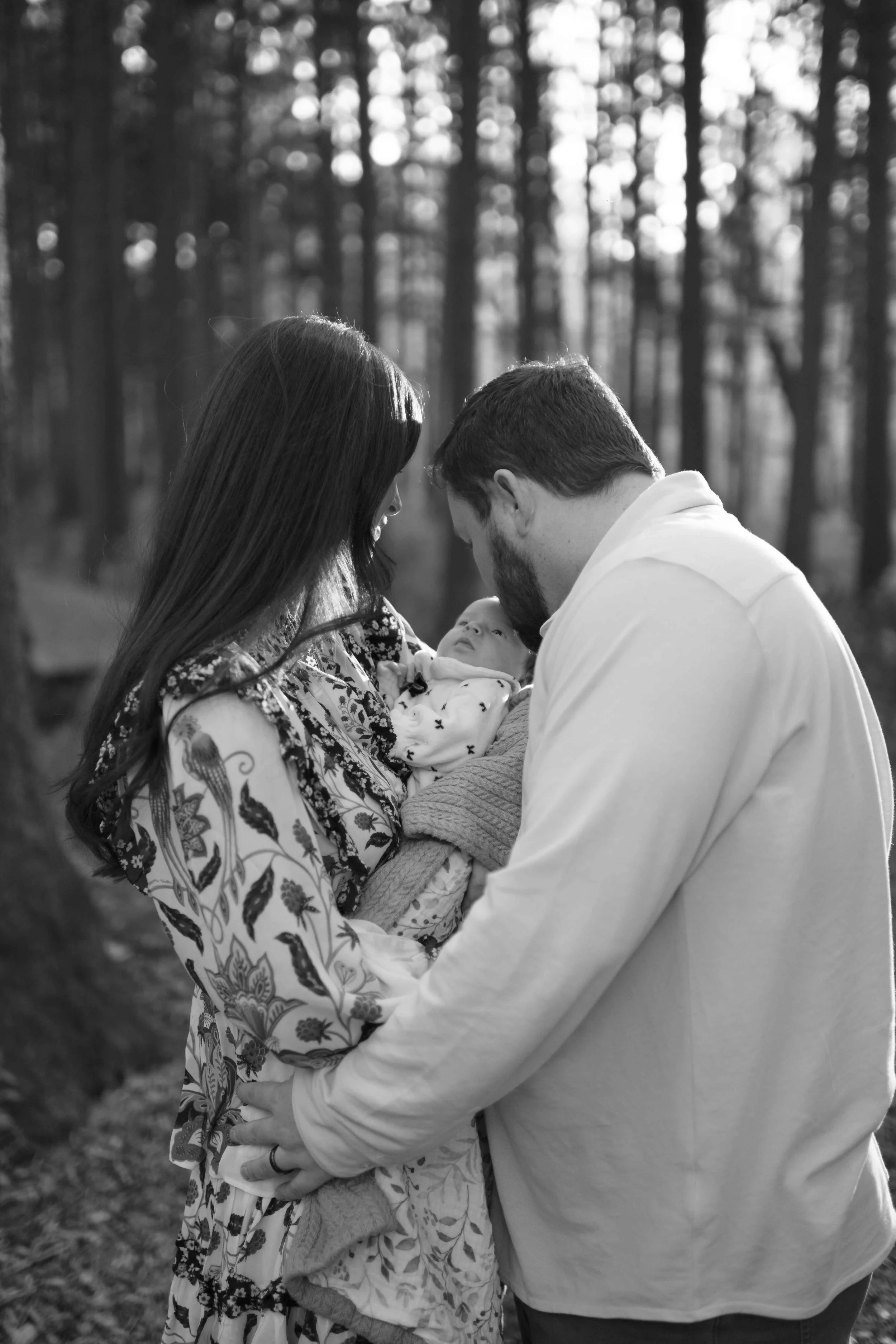 black and white photo of dad kissing newborn baby head at Morton Arboretum Lisle IL 