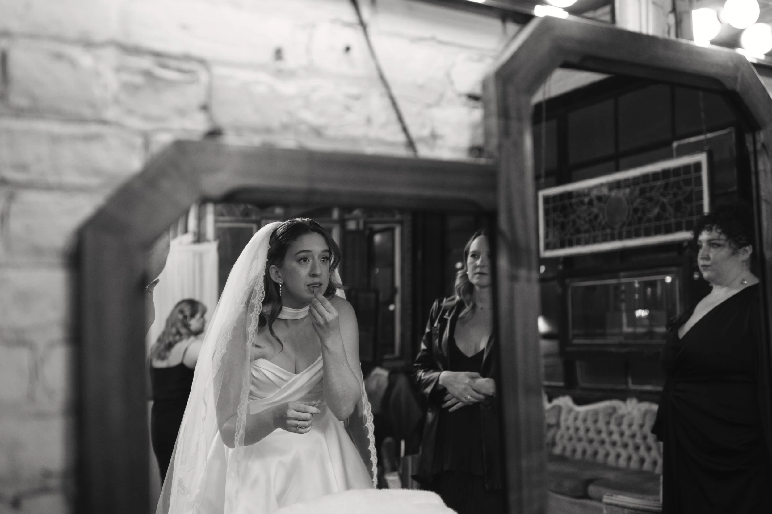 black and white photo fixing her lipstick at Salvage One in Chicago IL