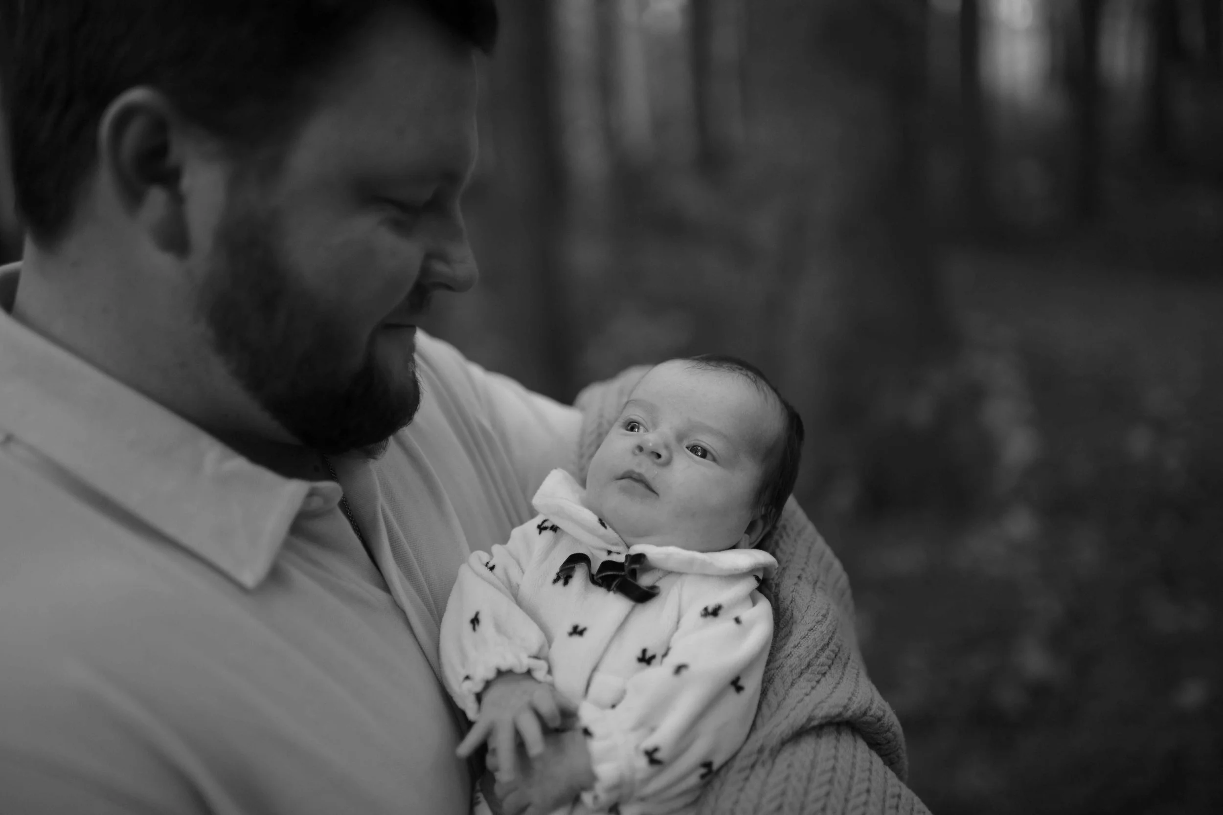 daddy cuddling newborn baby daughter at Morton Arboretum Lisle IL 