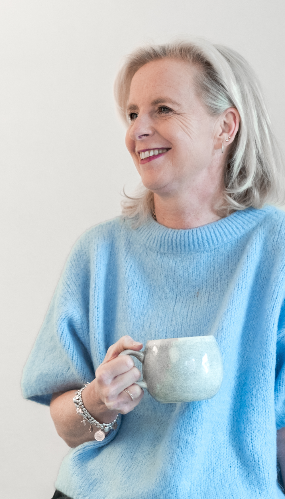 Portret van Ivy Ronda, coach en trainer in Maastricht, glimlachend met een keramieken mok tijdens een persoonlijke coachingssessie. Foto door Nikol Pecka Photography van Stardust Media Studio.