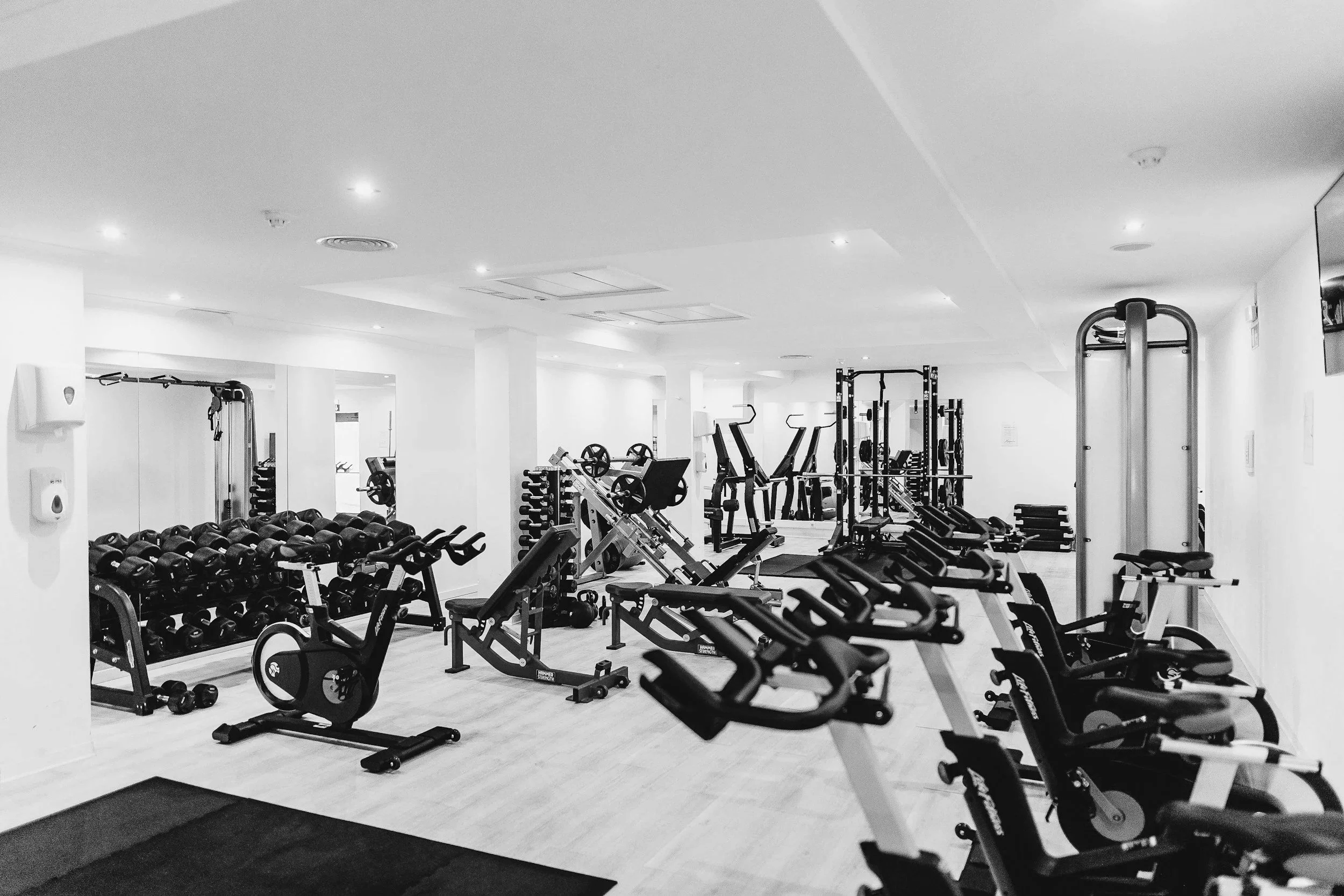 Fitnessruimte met cardio- en krachtapparatuur, gewichten en spiegels. In Scheveningen, Den Haag.