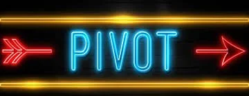 Neon sign with the word 'PIVOT' in blue, flanked by red arrows pointing right.