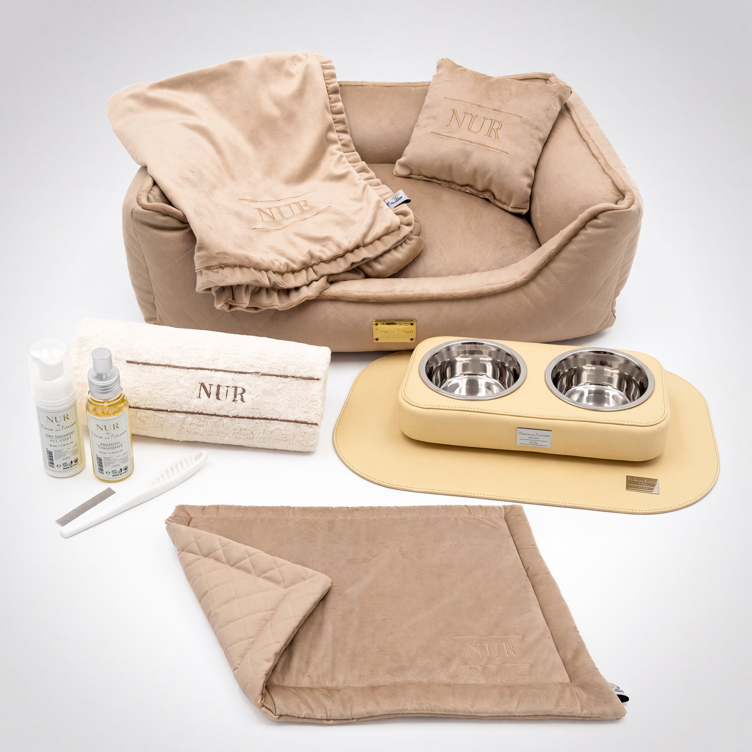 Set di accessori per animali domestici con cucce, ciotole in acciaio, asciugamano e prodotti per la cura, tutto in tonalità beige e crema con scritte sul brand 'NUR'.