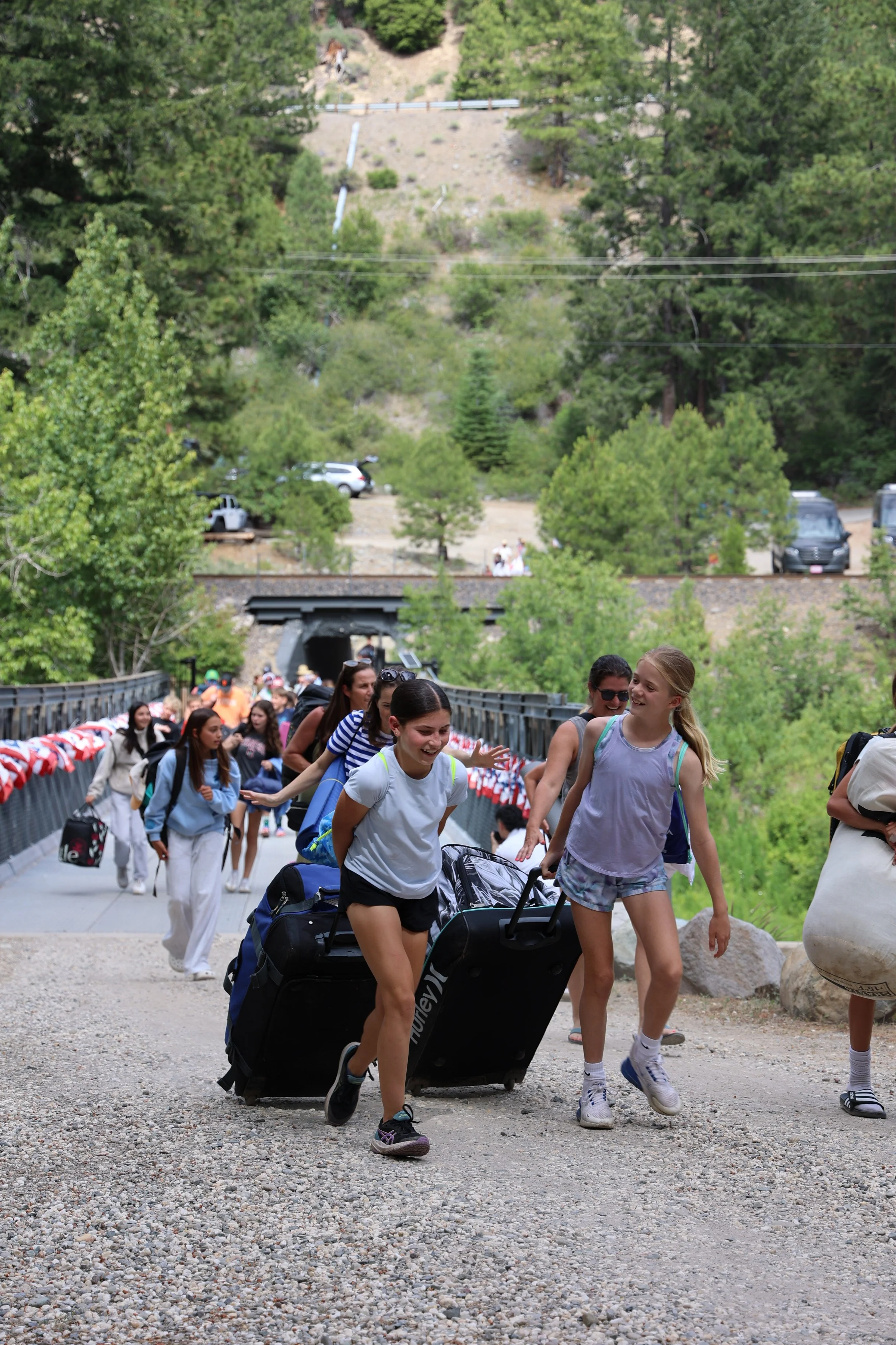 Group of kids arriving at camp with their luggage.