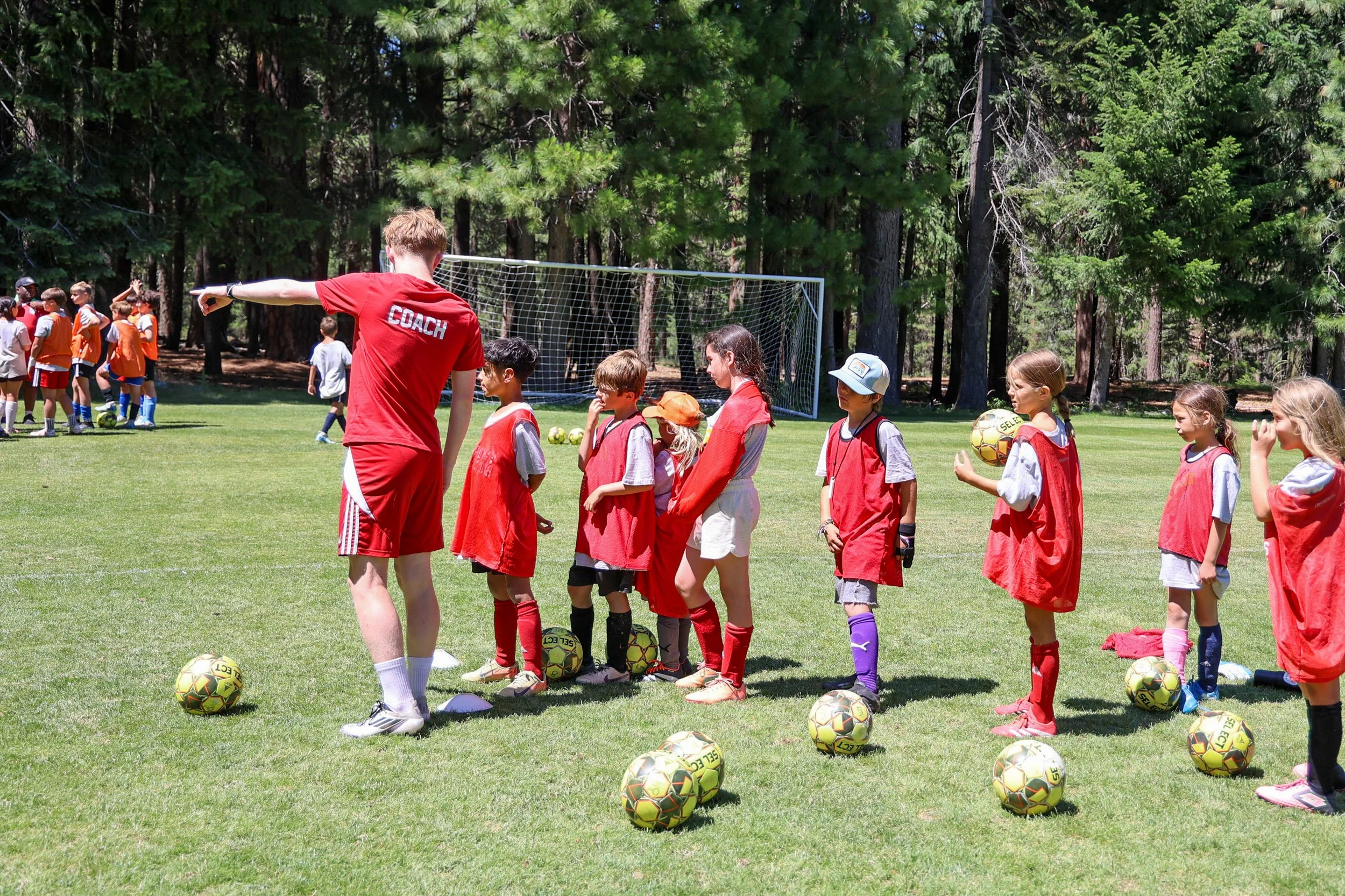 Soccer coach guiding young players during training at Two Rivers Soccer Camp
