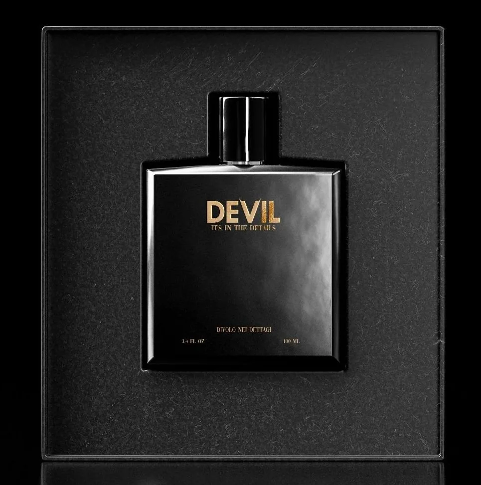 Black perfume bottle labeled "Devil" with gold lettering, presented in a black box.