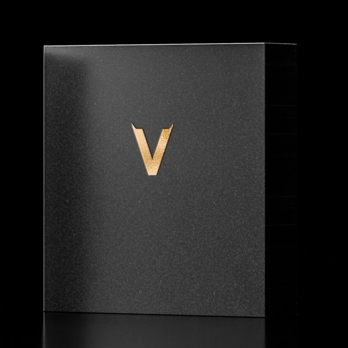 A black packaging box with a gold letter 'V' on the front.