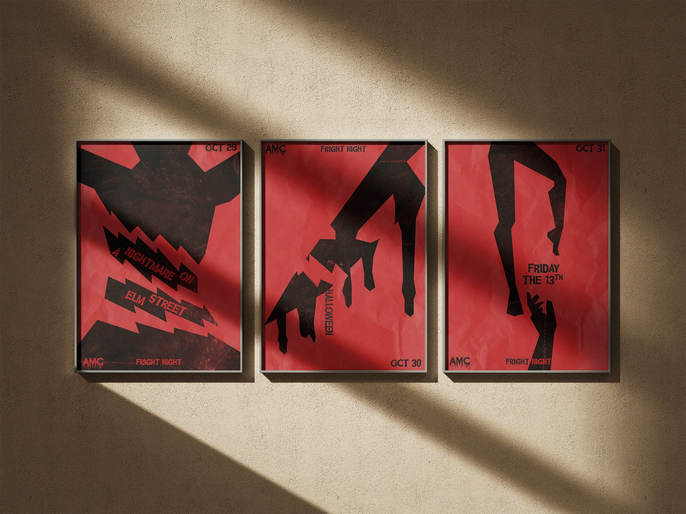 Three vintage horror movie posters with red backgrounds and black artwork are displayed on a beige wall. Shadows cast diagonally across the posters.