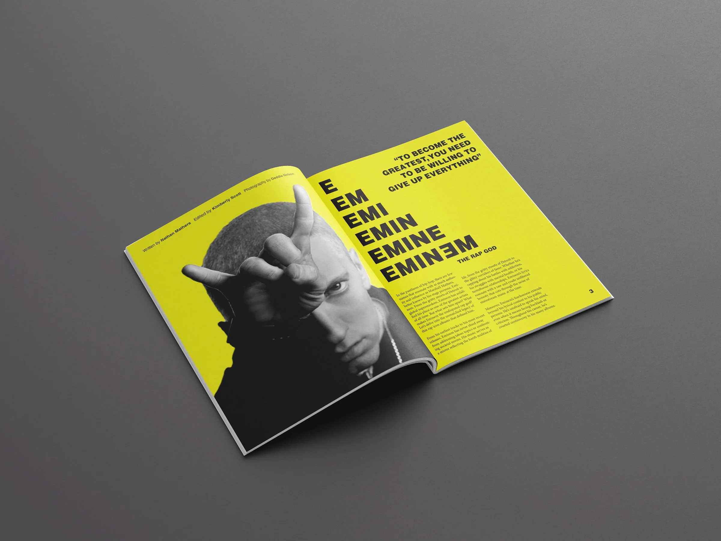 An open magazine with a bright yellow background featuring a grayscale photo of a person making a hand gesture. The right page includes bold black text with repeated words 'E', 'EMI', 'EMIN', 'EMINE', 'EMINEM', and a quote from Eminem, 'To become the