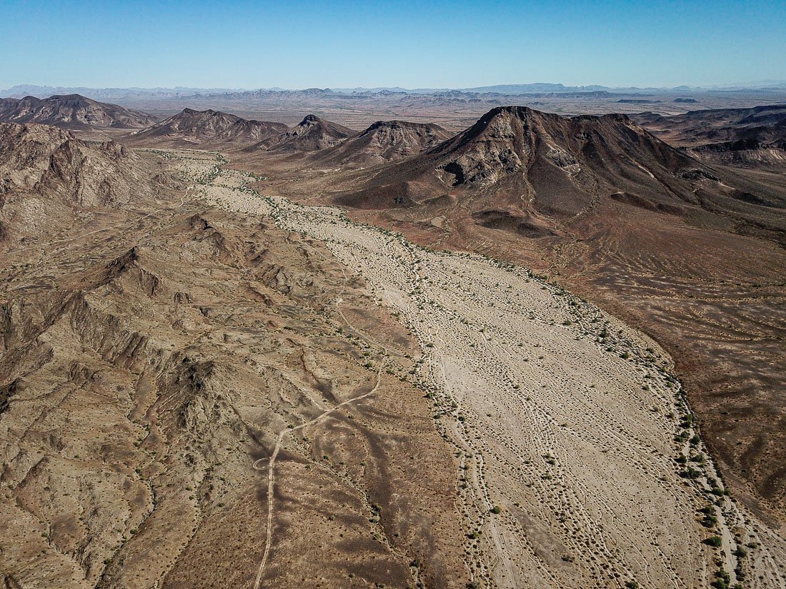 A wide unnamed wash slices through the charred volcanic landscape of the Palomas Mountains in southwestern Arizona.