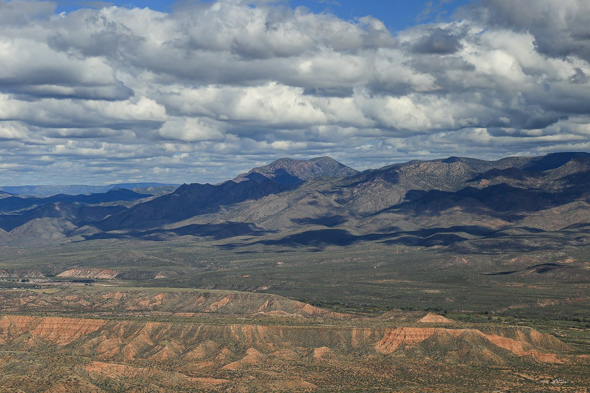Puffy clouds above red hills in Tonto Basin.