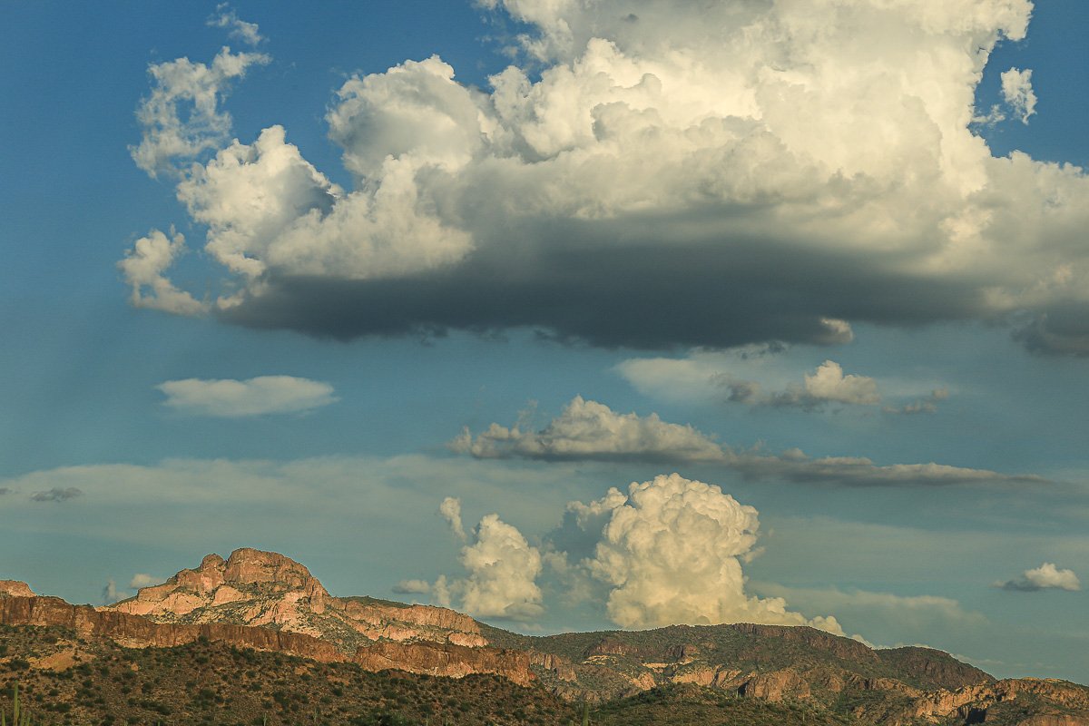Billowy castles in the sky over volcanic mountains.
