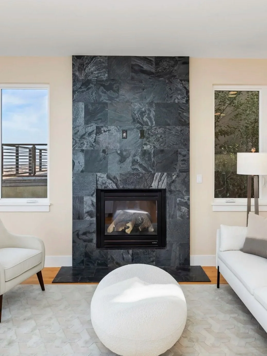 Modern living space with a central fireplace in contemporary dark tile.