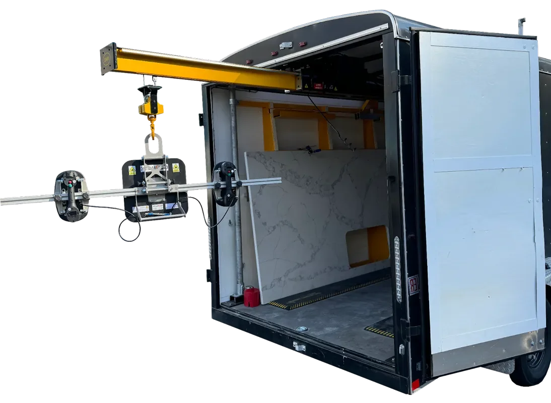 Mobile workshop or studio with a marble wall panel, equipped with a ceiling crane, an extendable arm with a clamping device for stone slabs, and interior organized with construction tools and materials.
