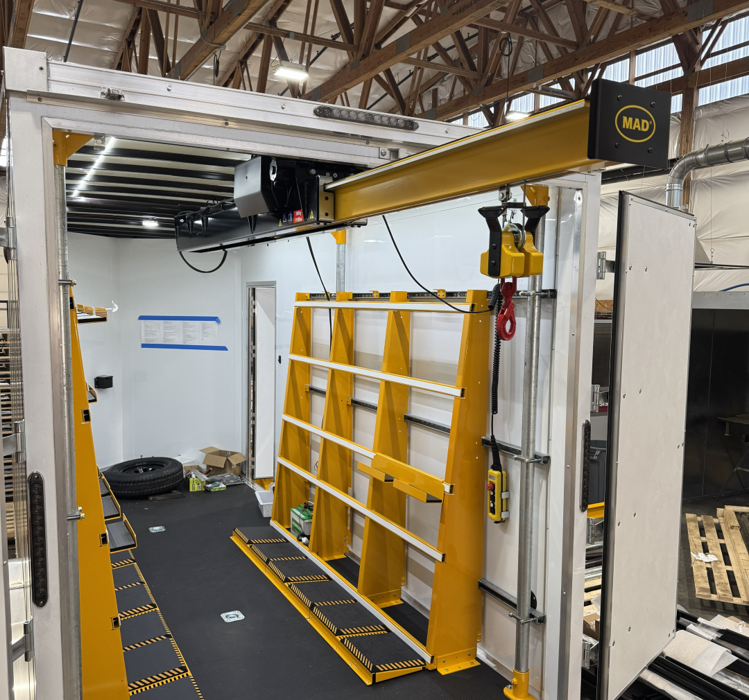 A yellow and black industrial vehicle lift inside a warehouse or workshop.