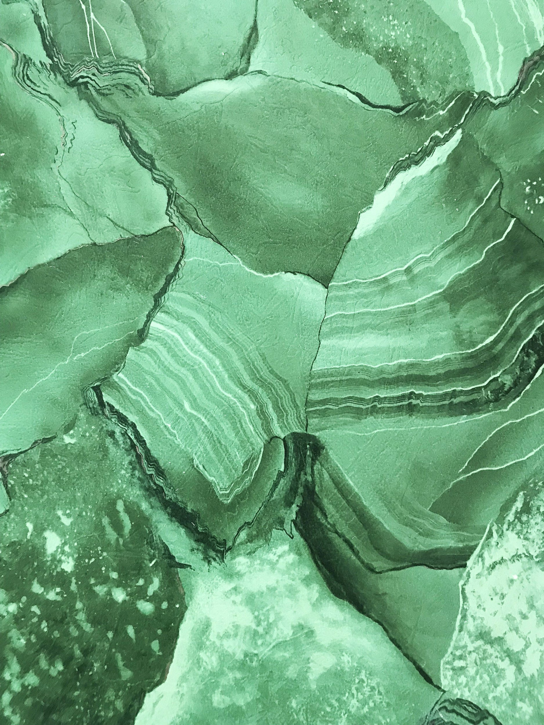 Close-up of green malachite stone with layered and banded patterns.