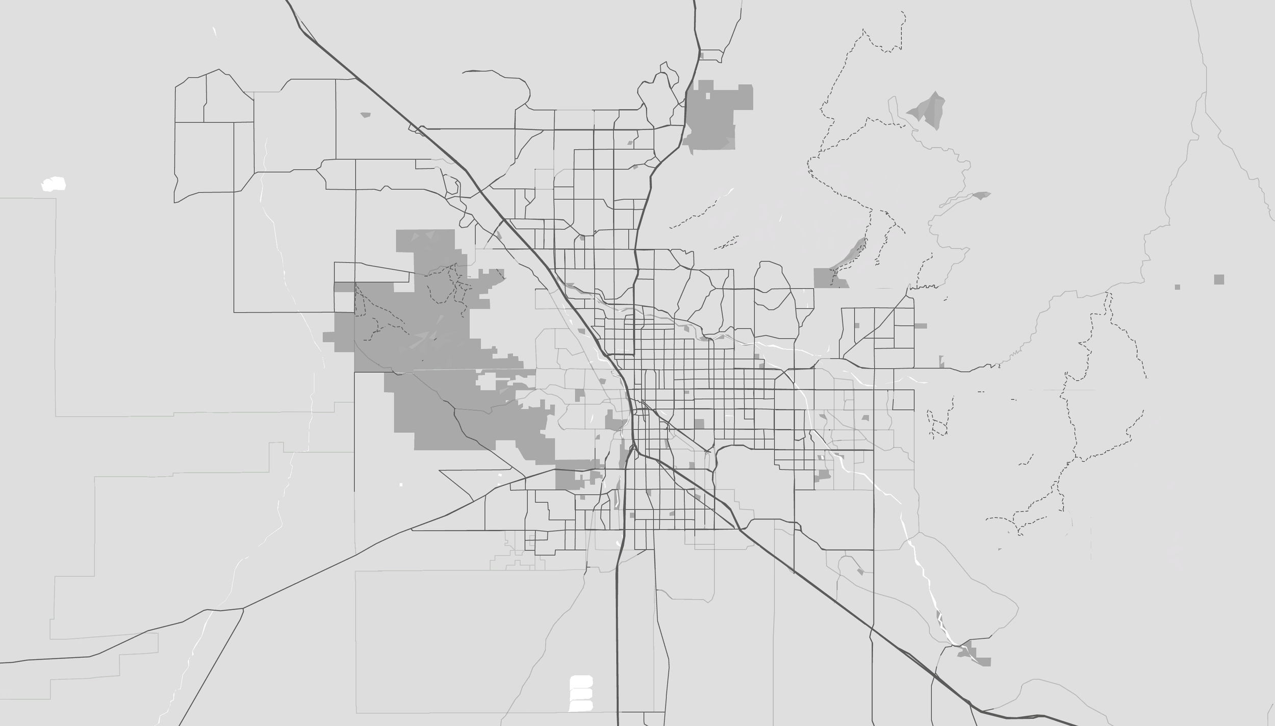 A grayscale map of a city with various roads and geographic features outlined.