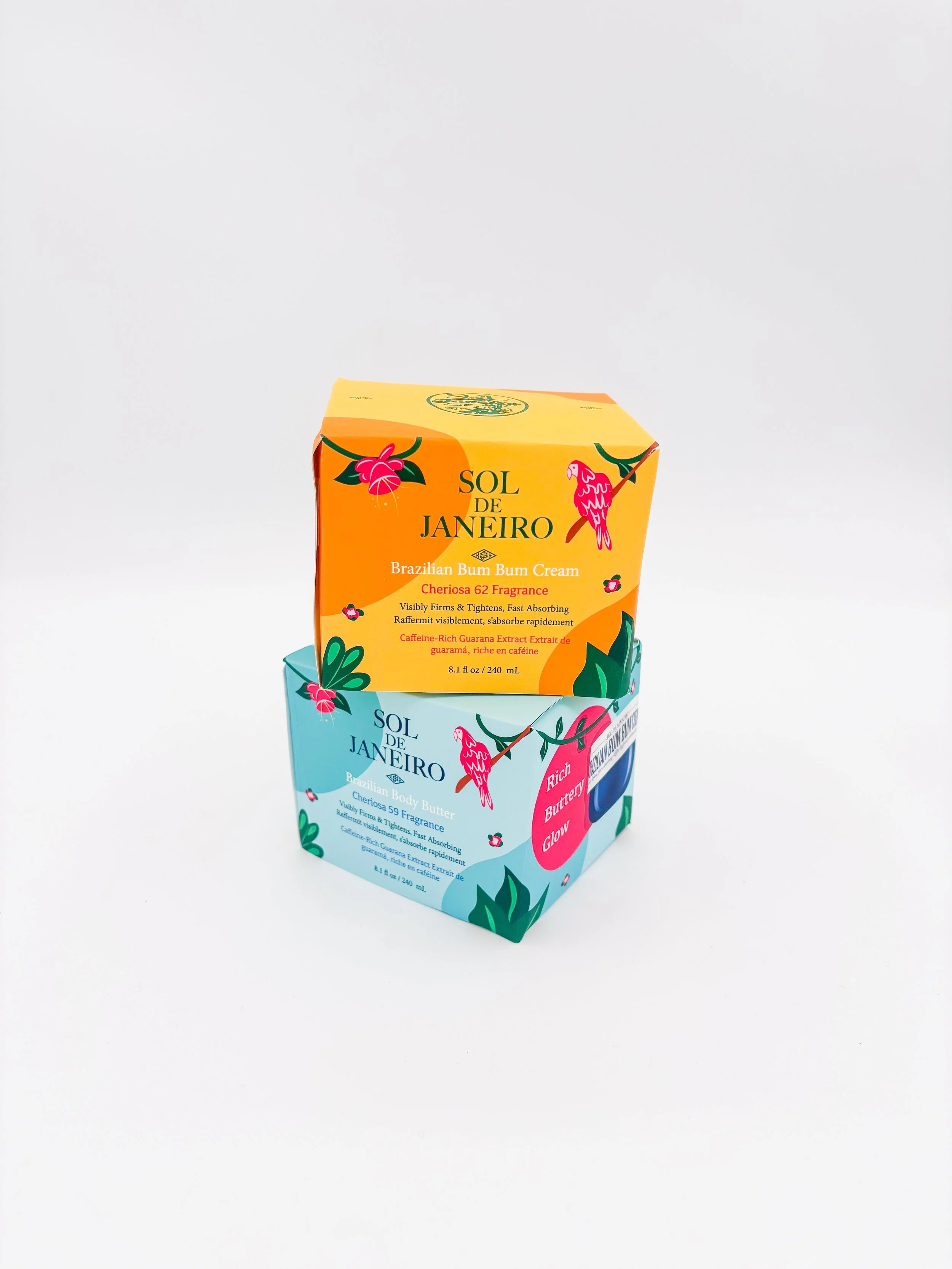 Two skincare product boxes from Sol de Janeiro, one labeled Brazilian Bum Bum Cream with Cheriosa 62 Fragrance in a yellow-orange box, and the other labeled Brazilian Body Butter with Cheriosa 59 Fragrance in a light blue box, against a plain white background.
