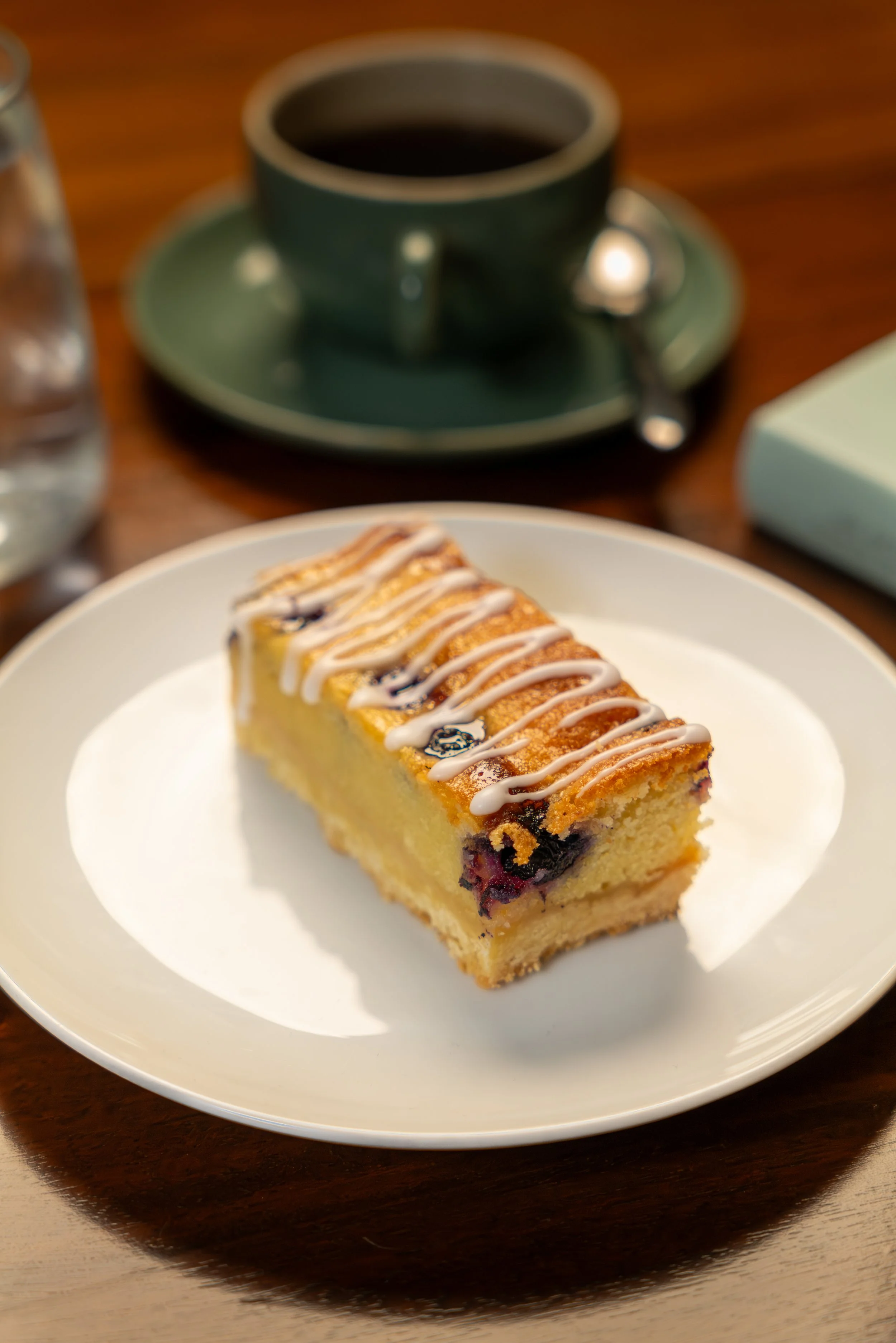 Lemon and Blueberry slice, with a buttery shortbread base and lemon frangipane filling studded with blueberries, and a lemon syrup drizzle for extra lemon flavour.