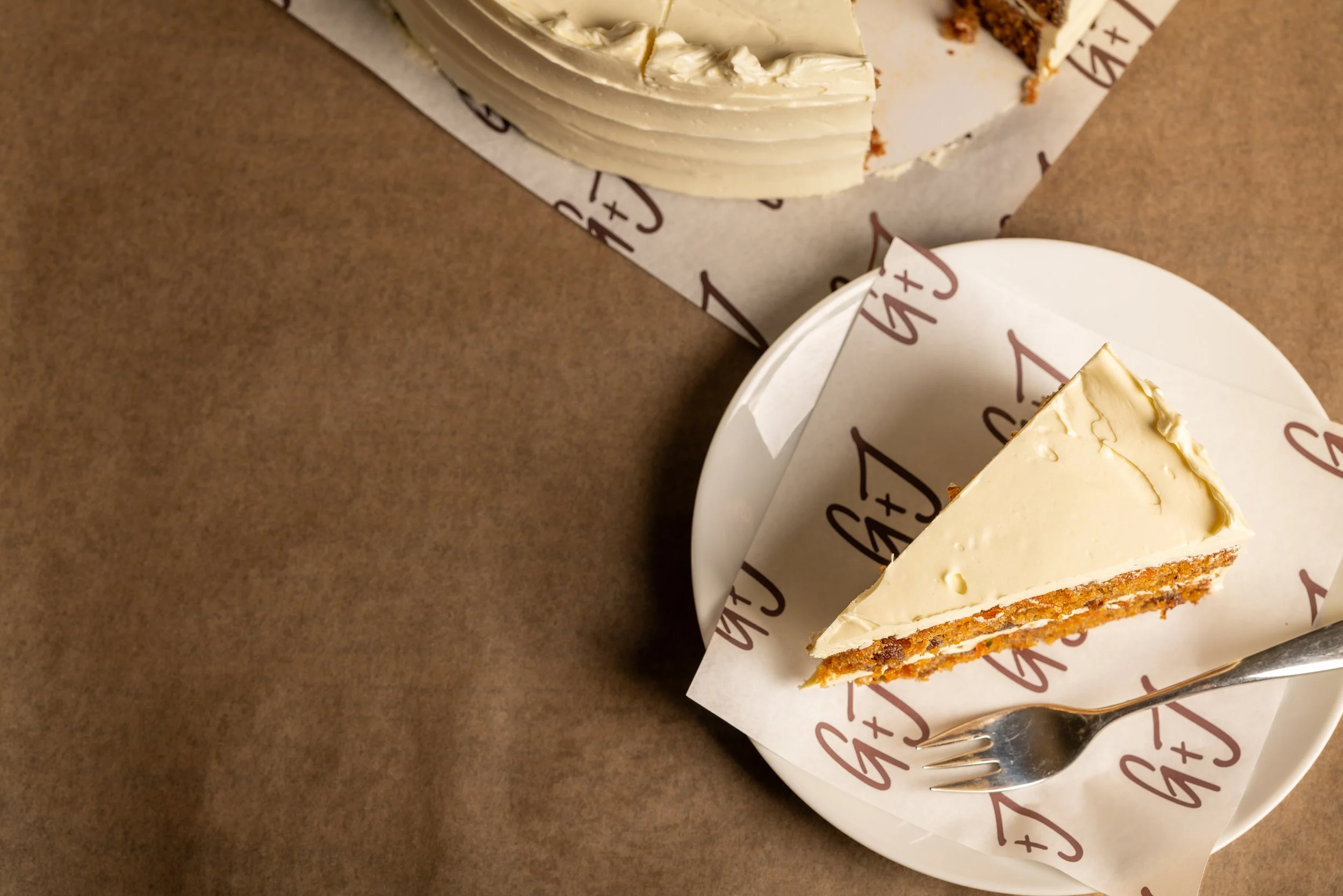 Fruity, spiced carrot cake with orange buttercream frosting. 10" cake, serves 12-16.