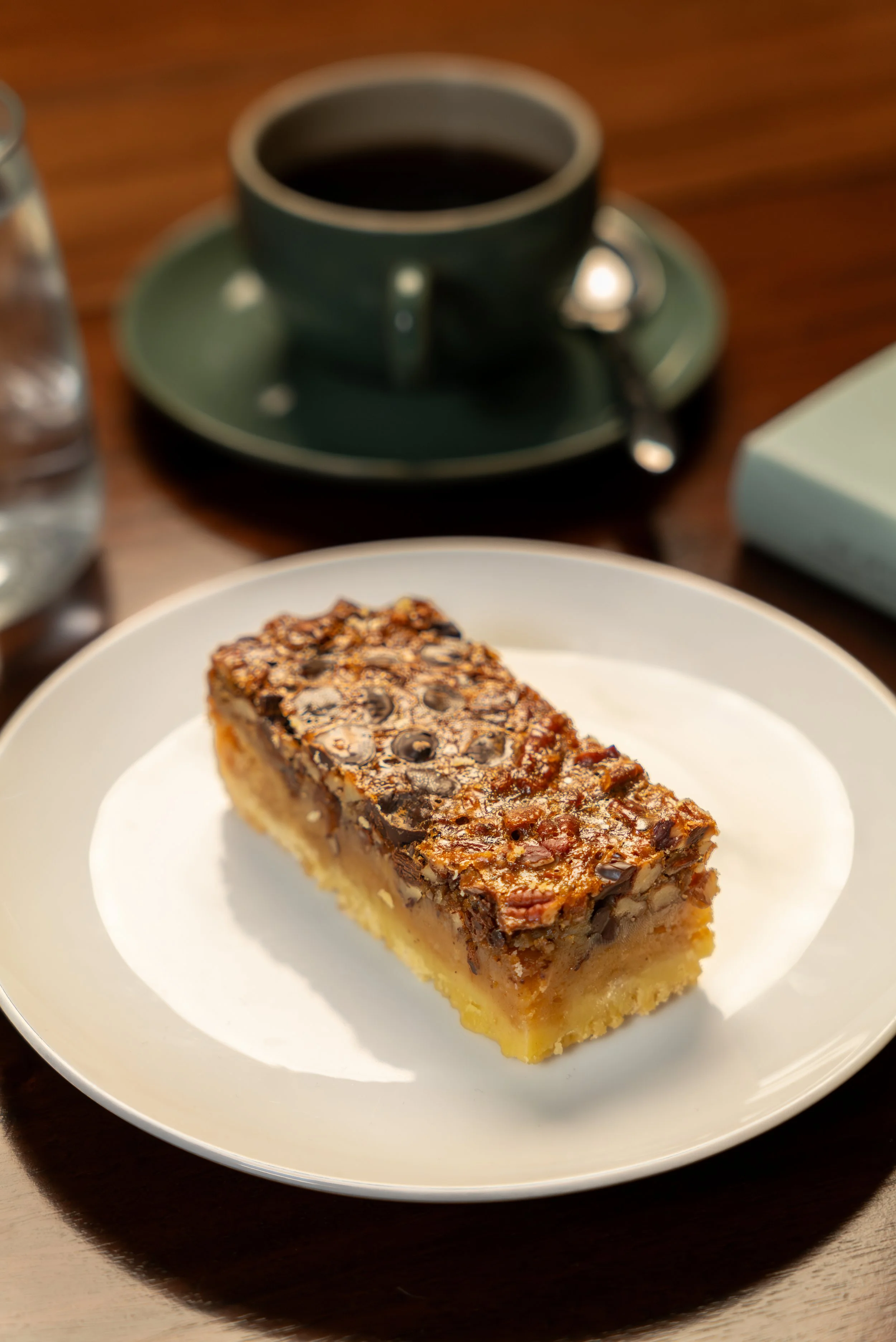 Pecan Shortbread slice, with a buttery shortbread base, gooey filling, toasted pecans, dark chocolate chips and a generous sprinkling of Maldon sea salt.