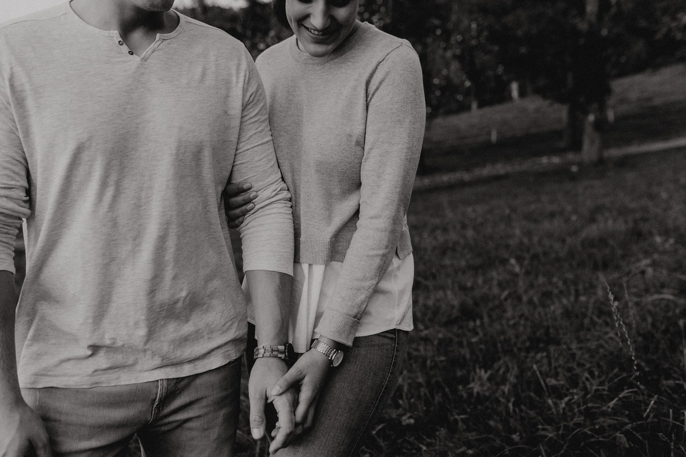 Nahaufnahme von einem Paar, das im Freien steht, Händchen haltend, lachend und sich gegenseitig ansieht.