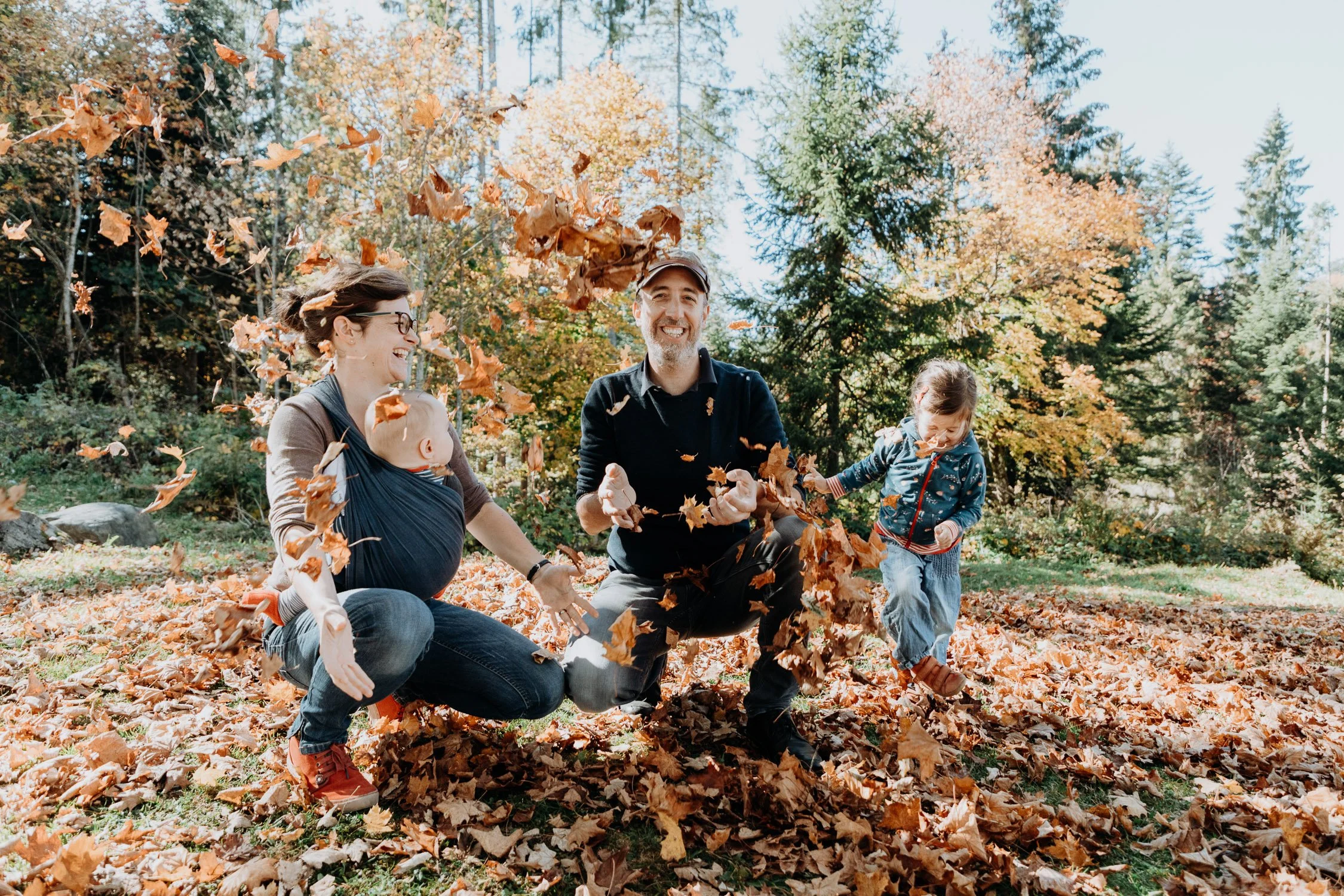 Familie spielt im Herbstlaub in einem Wald