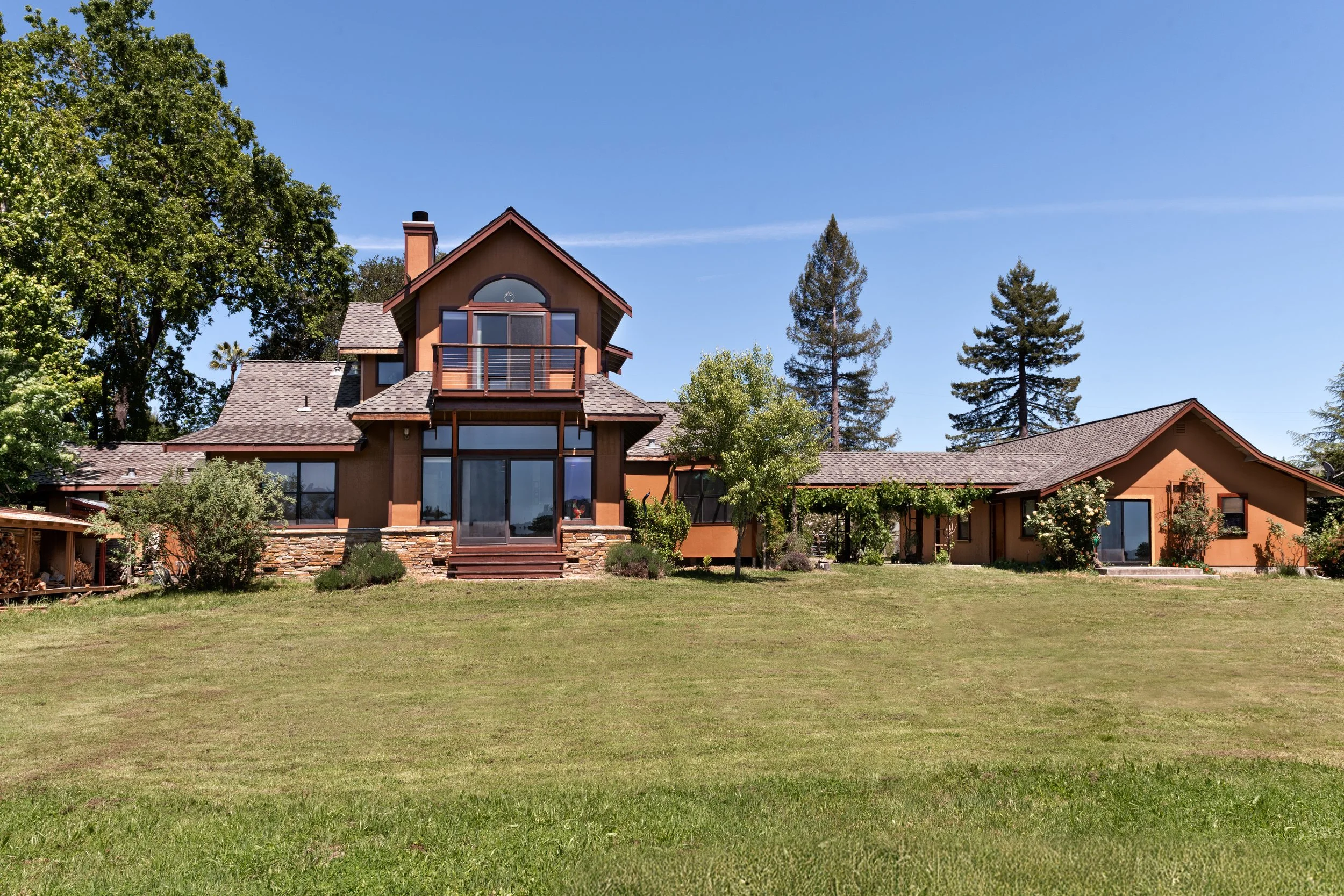 A large house located in Sebastopol with a well-maintained lawn, surrounded by trees, under a clear blue sky.