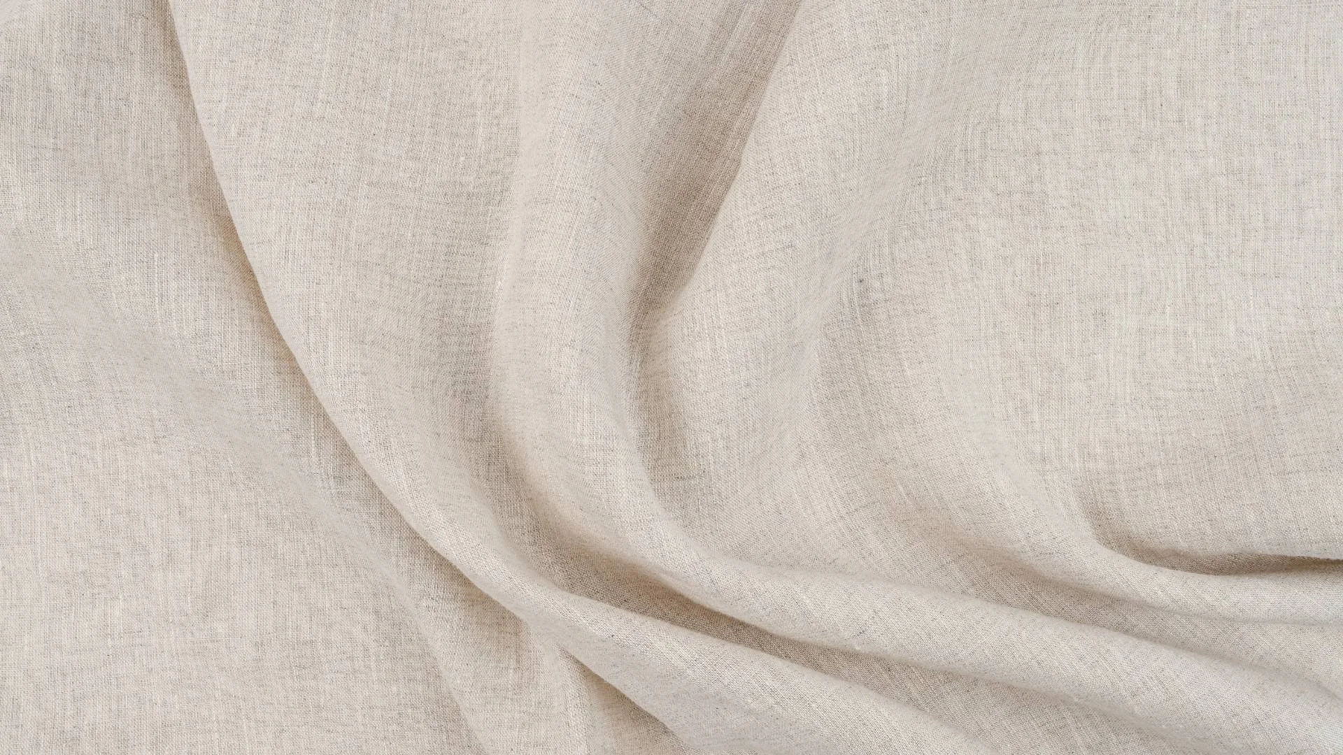 Close-up of a beige fabric with soft folds and texture.