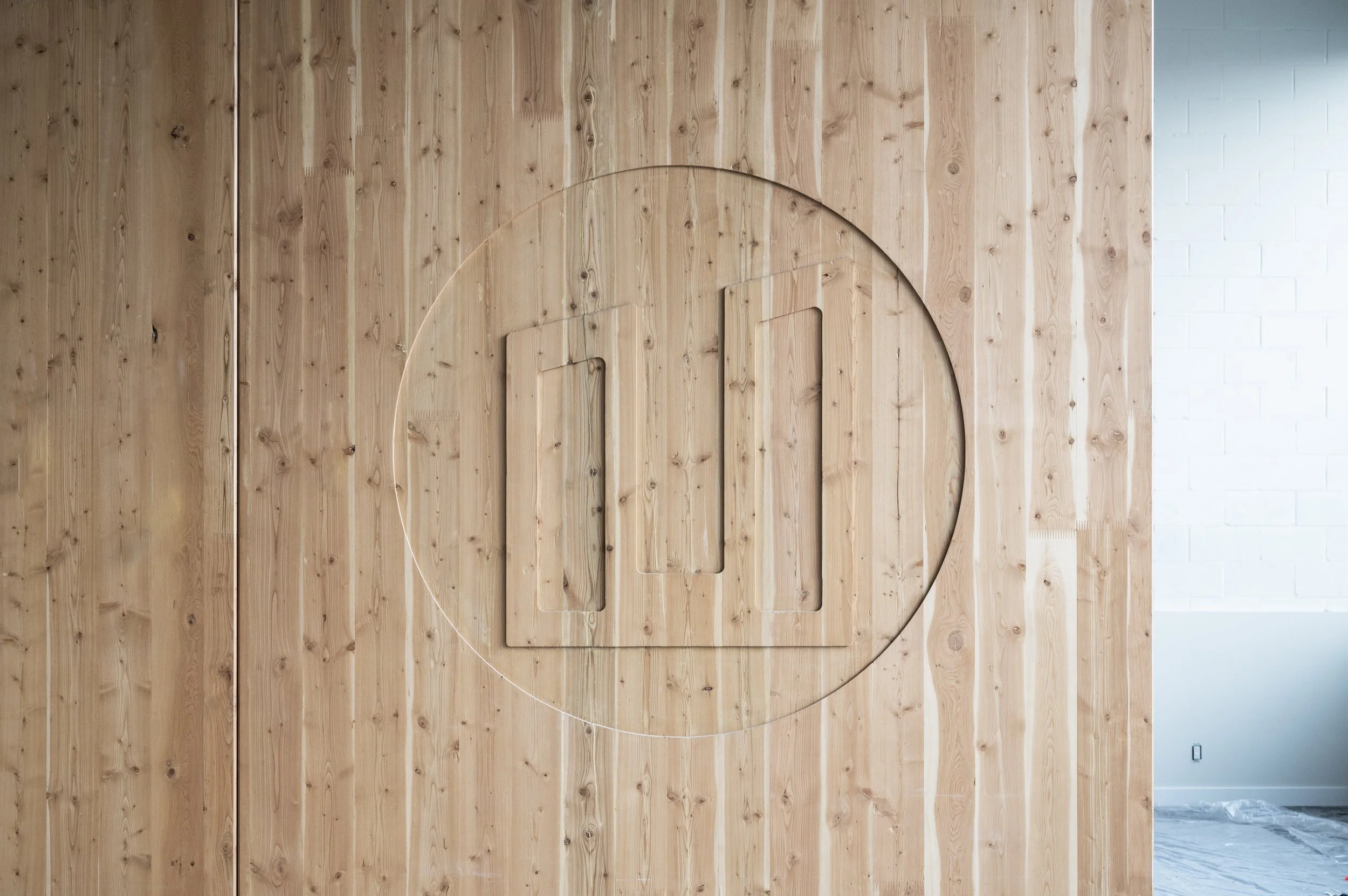 Interior view of a wooden wall with a transparent circular decor and a glass frame mounted on the wood.