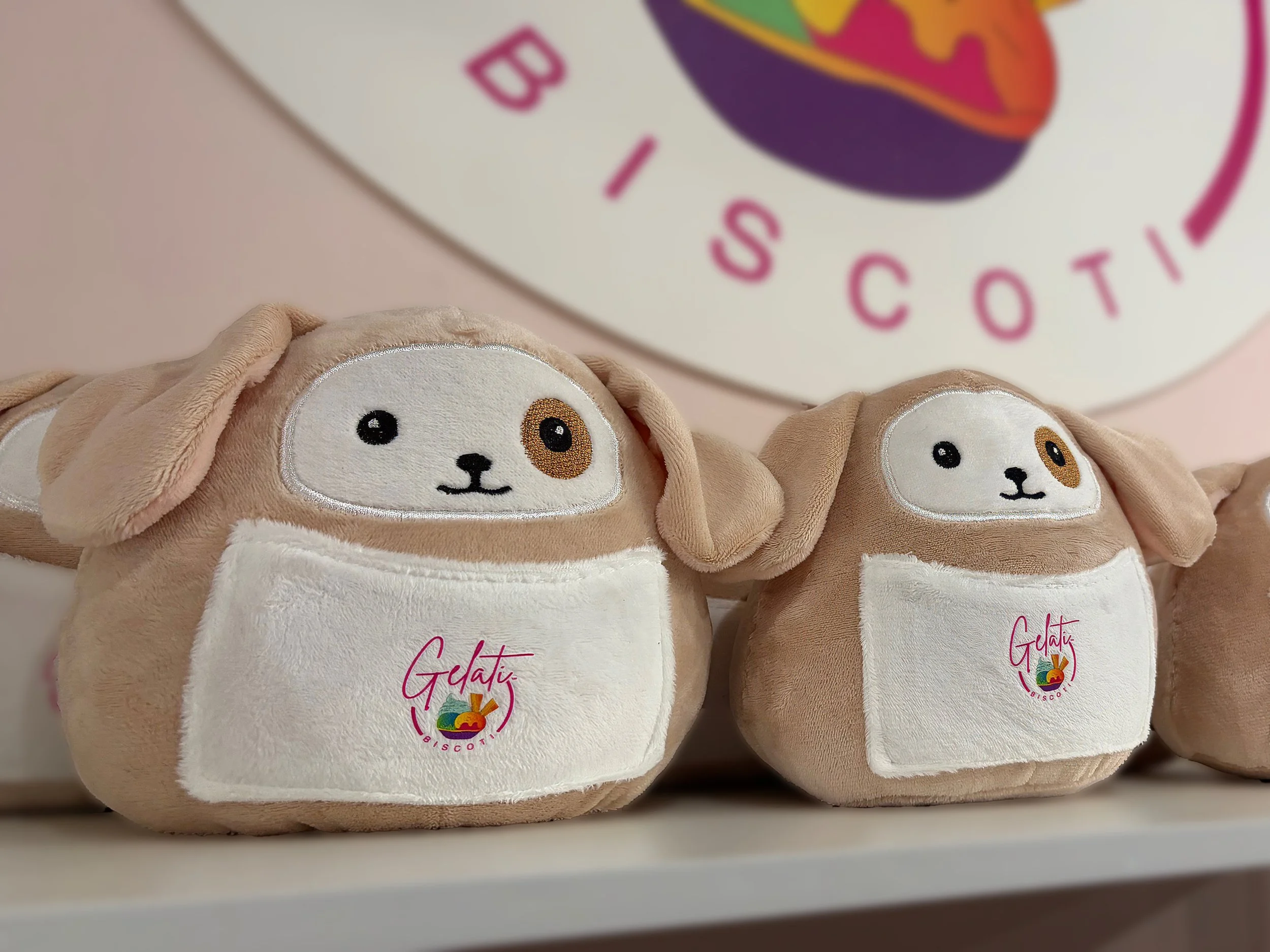 Two Gelati Biscoti toy dogs with beige fur and white patches.