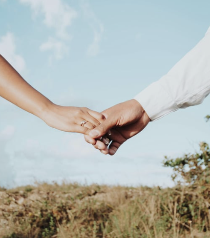 A copy holding hands in a field