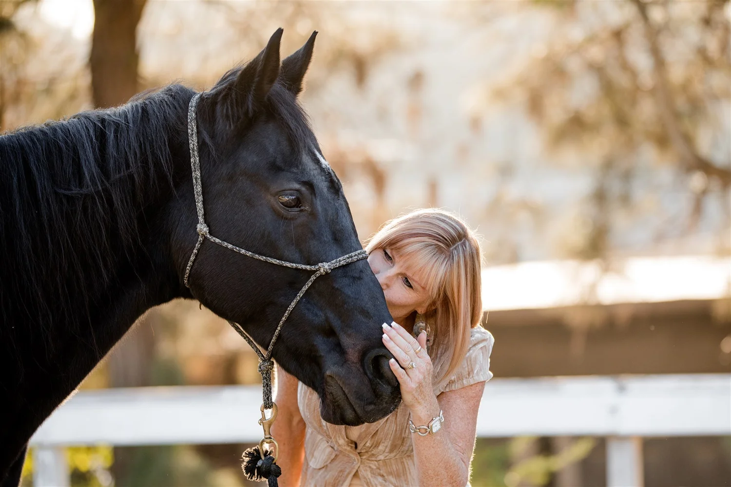 Michelle, the founder, kissing a black horse on the nose