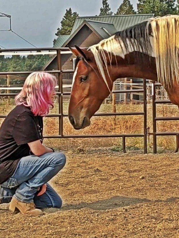 an event participant with pink hair connects with an equine coach