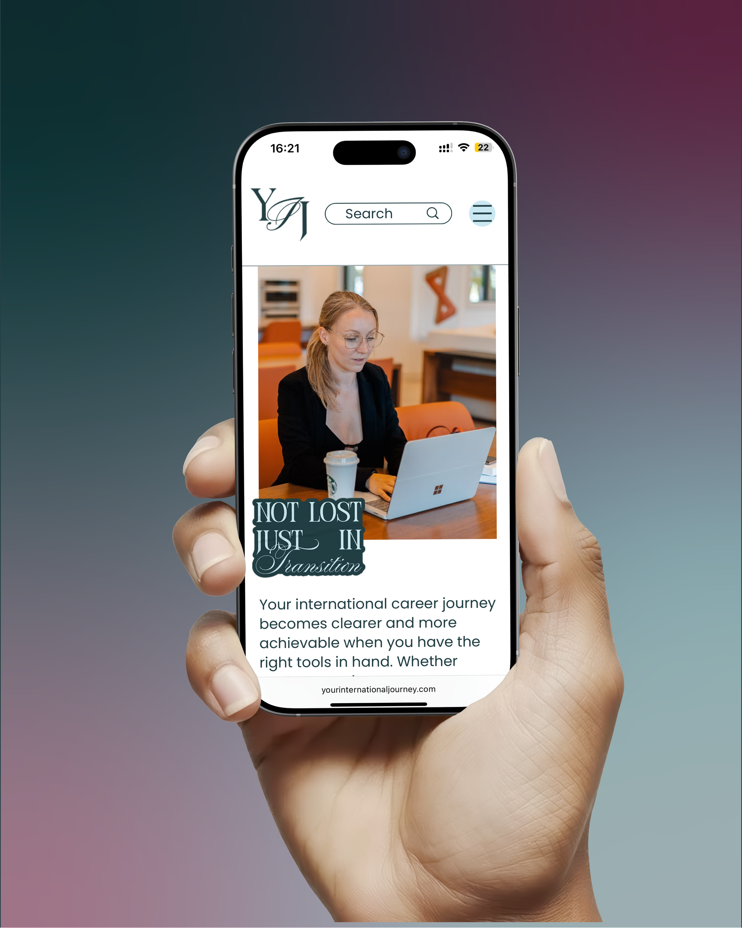 A hand holding a smartphone displaying a webpage with a woman working on a laptop indoors, with motivational text and website link.