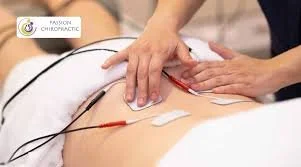 Chiropractic treatment with a practitioner applying adjustments to a patient's lower back using electrodes and hands.