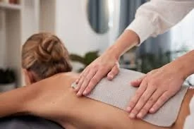 woman getting a hot pad on back for thermotherapy