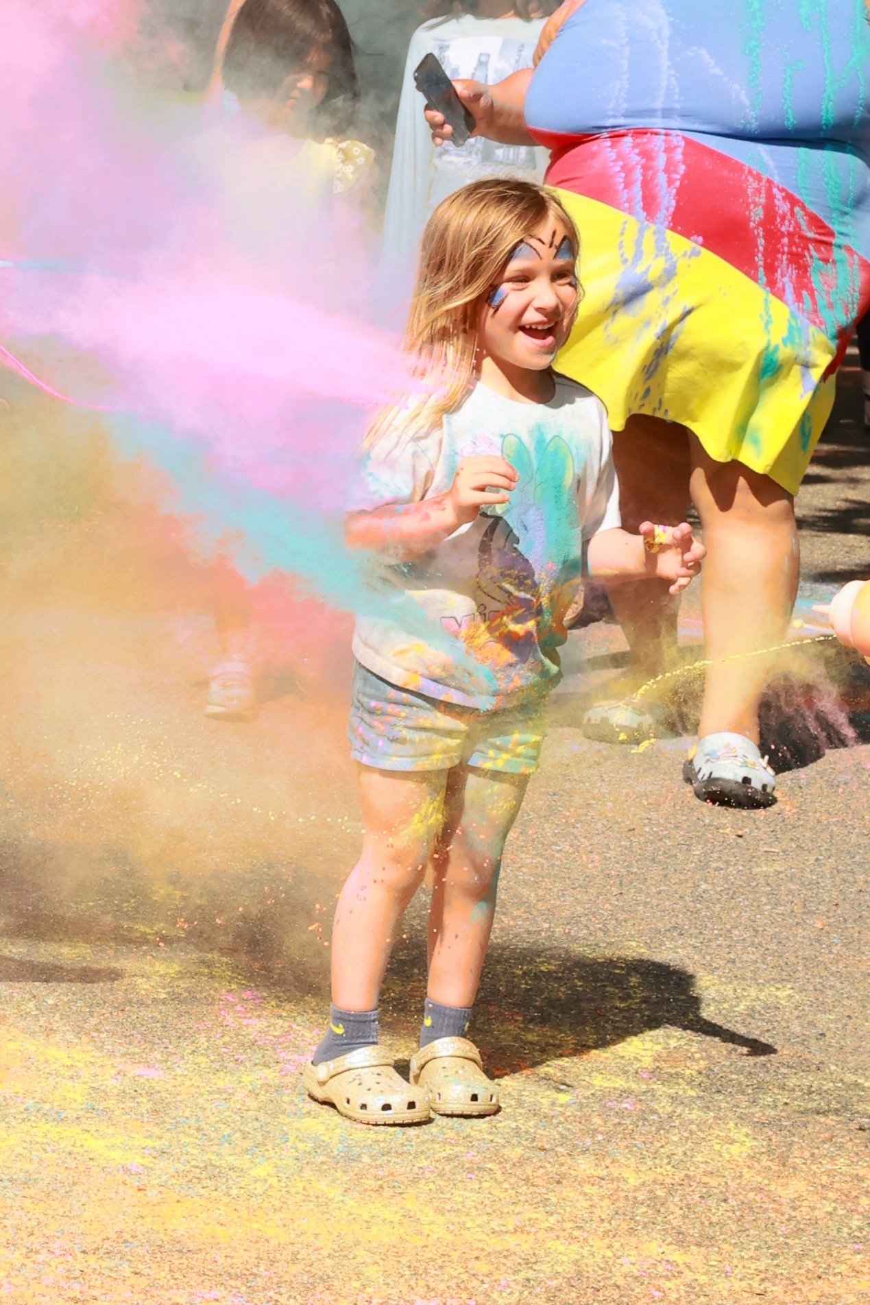 Photo of a girl being sprayed with color at OBHC's 2026 Color Walk.
