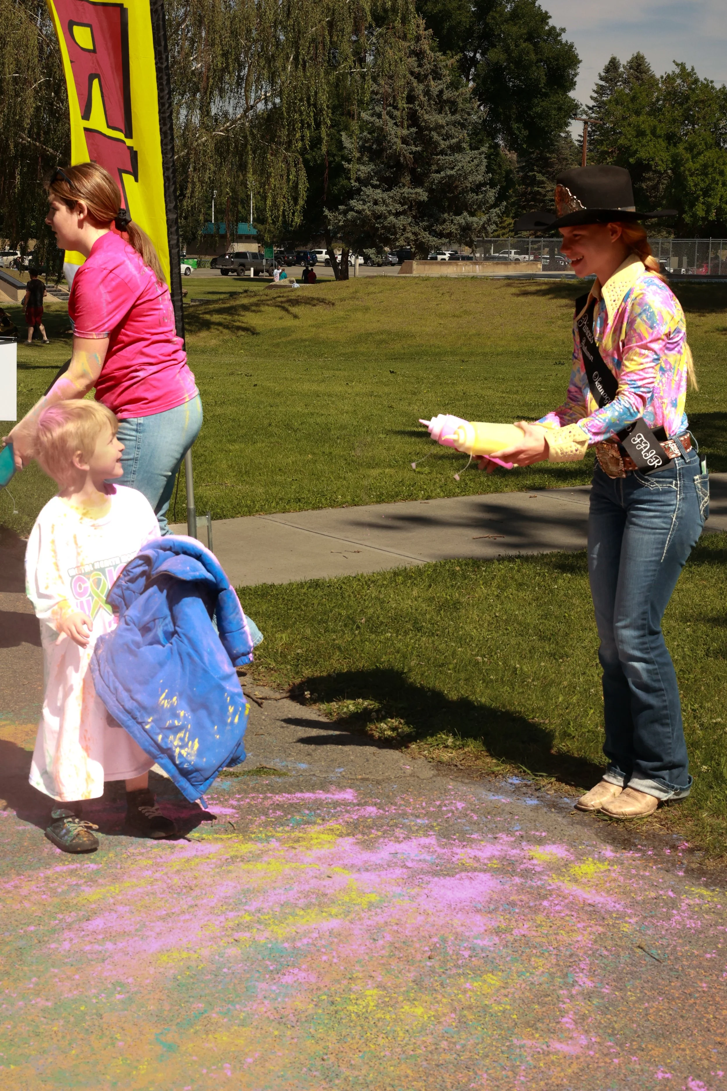 Photo of a boy being sprayed with color at OBHC's 2026 Color Walk.
