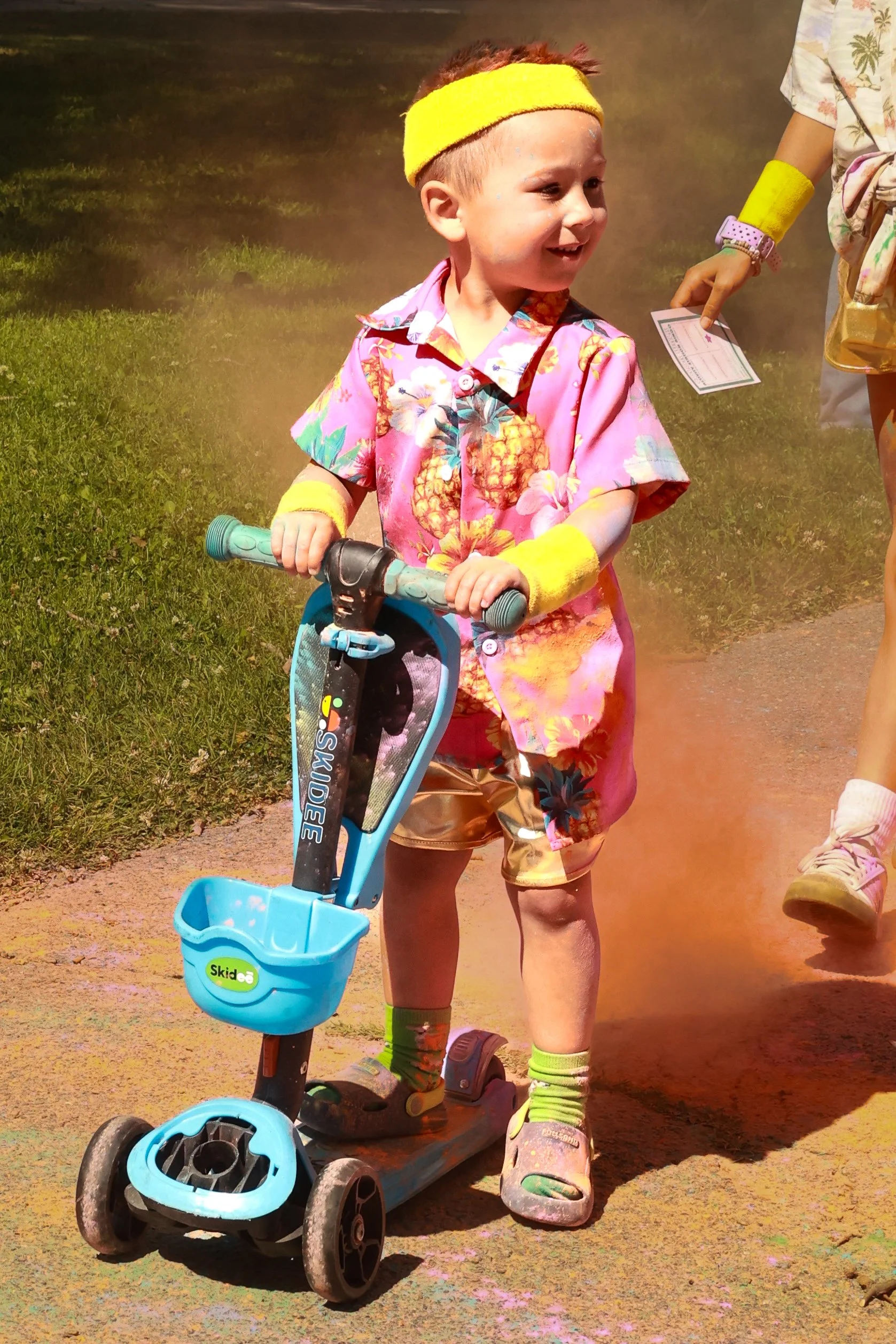 Photo of a young boy being riding his scooter at OBHC's 2026 Color Walk.