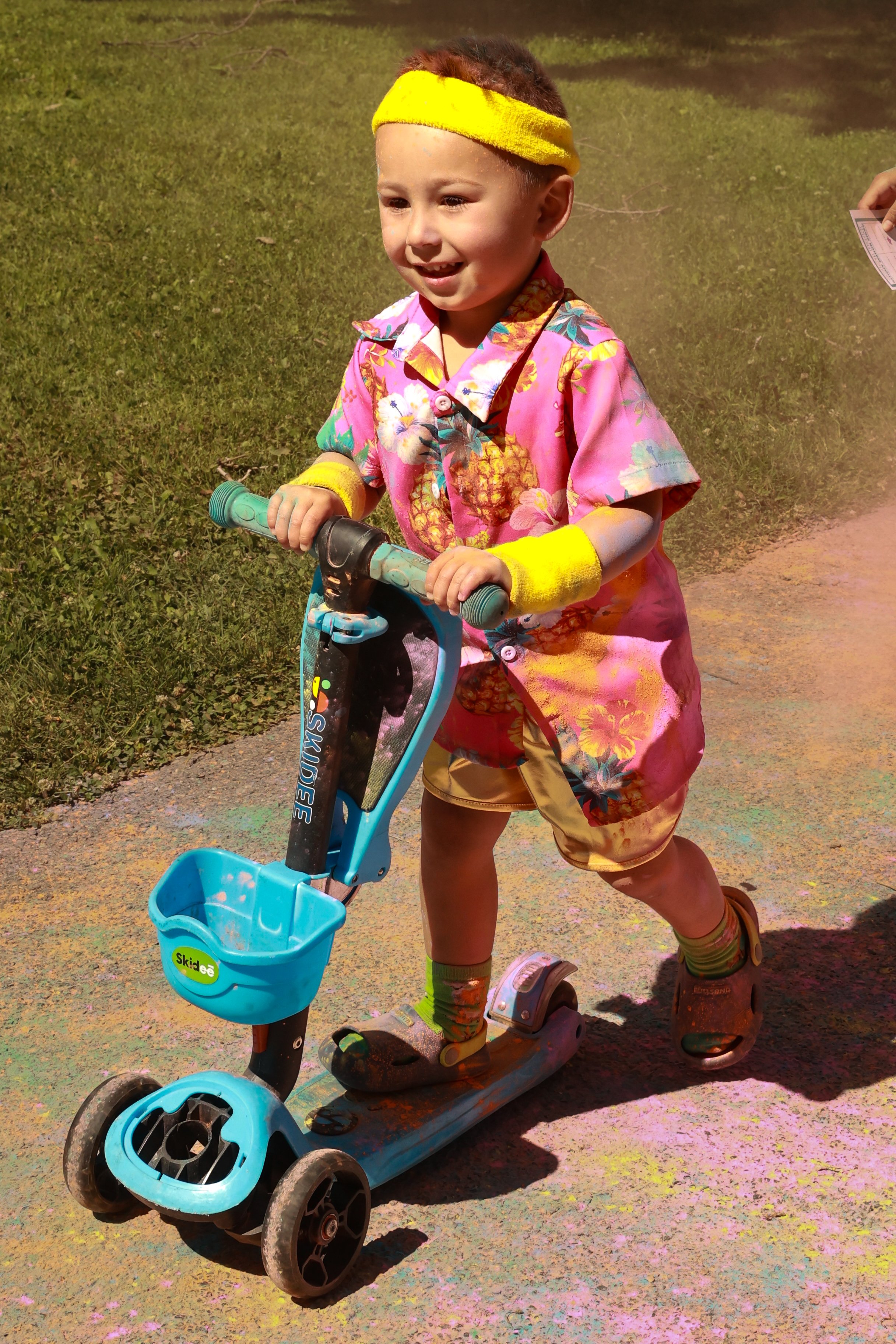 Photo of a young boy being riding his scooter at OBHC's 2026 Color Walk.