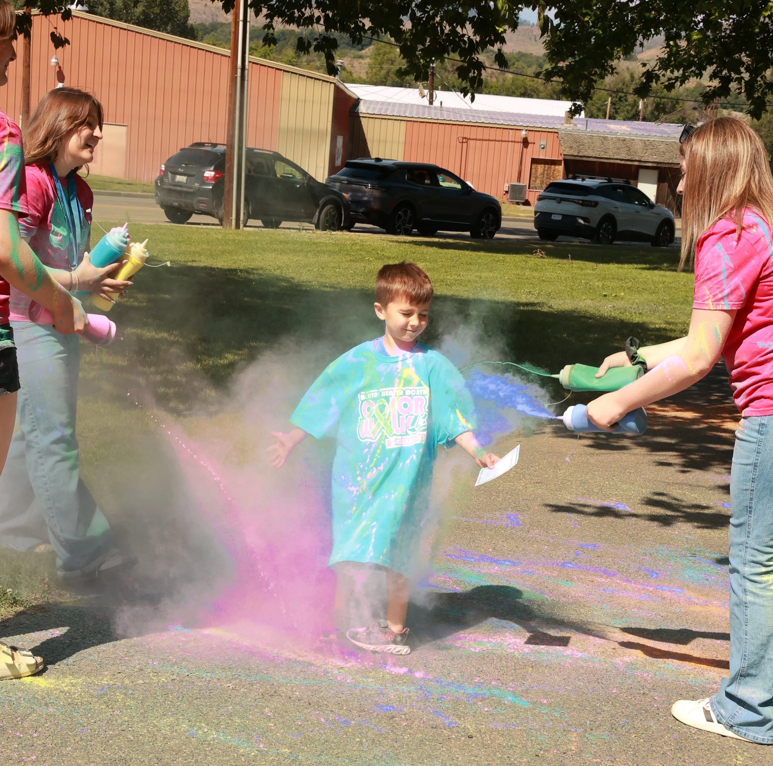 Photo of a boy being sprayed with color at OBHC's 2026 Color Walk.