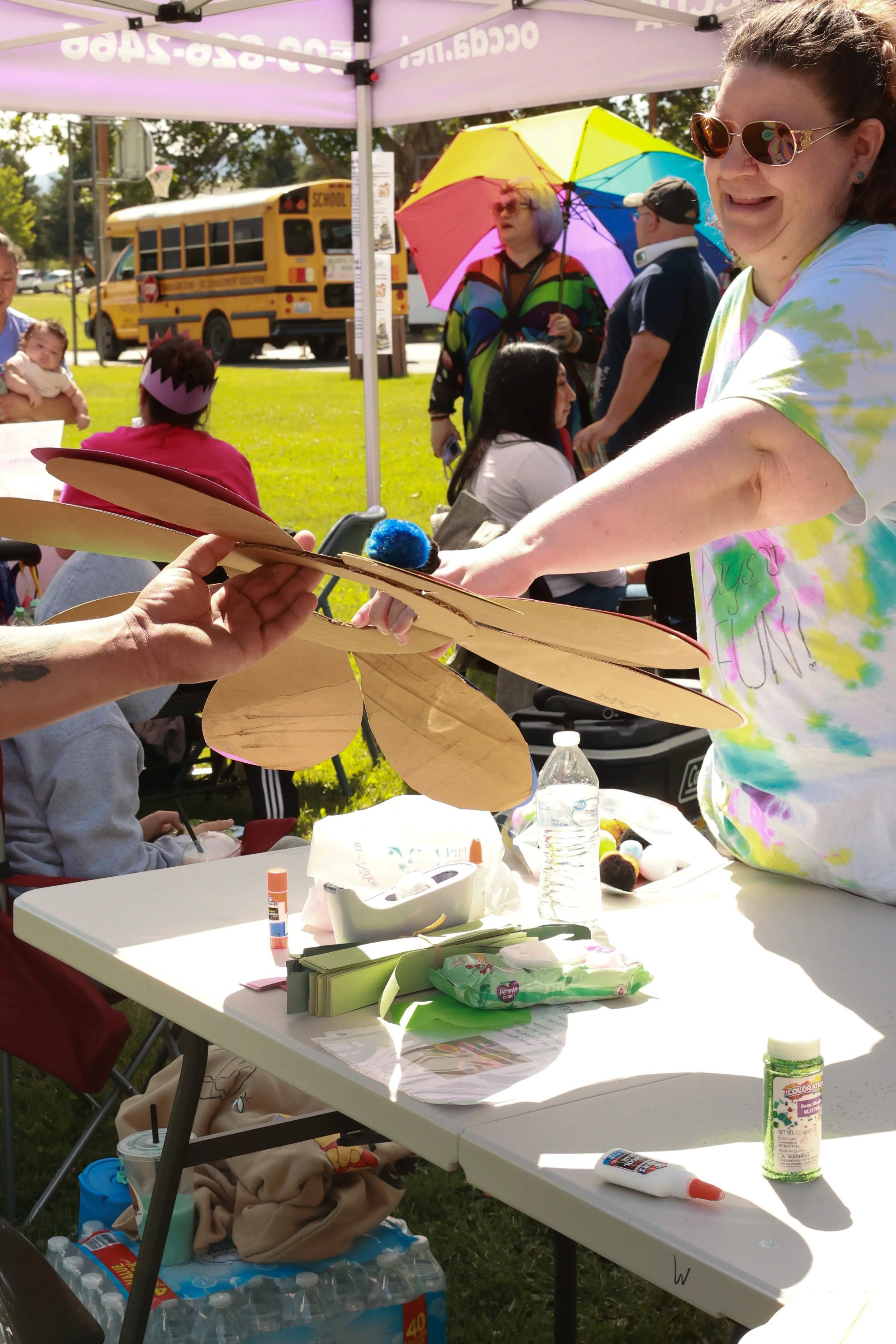 Photo of a an OCCDA employee giving a community member their finished craft at OBHC's 2026 Color Walk.