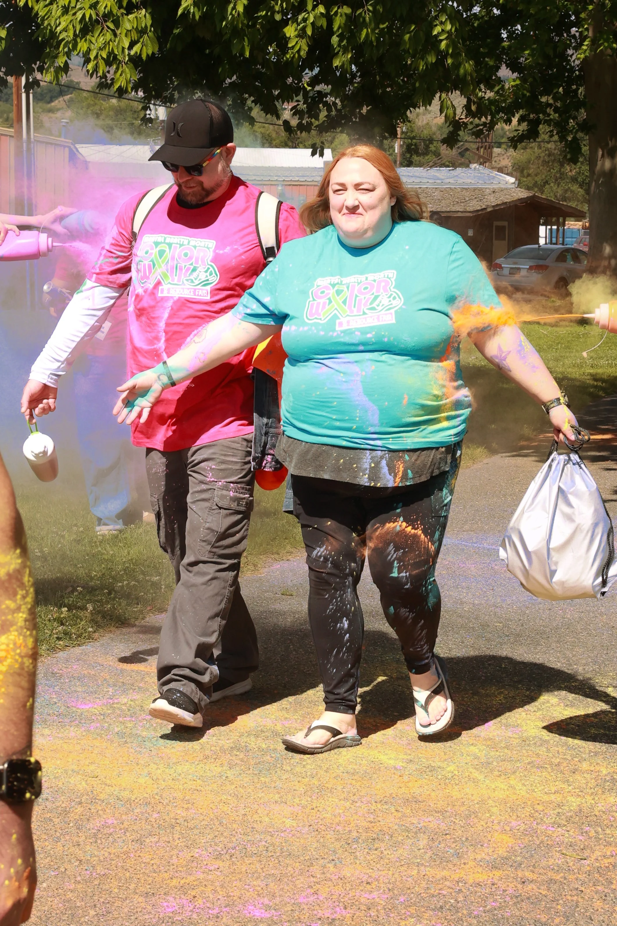 Photo of a man and a woman being sprayed with color at OBHC's 2026 Color Walk.