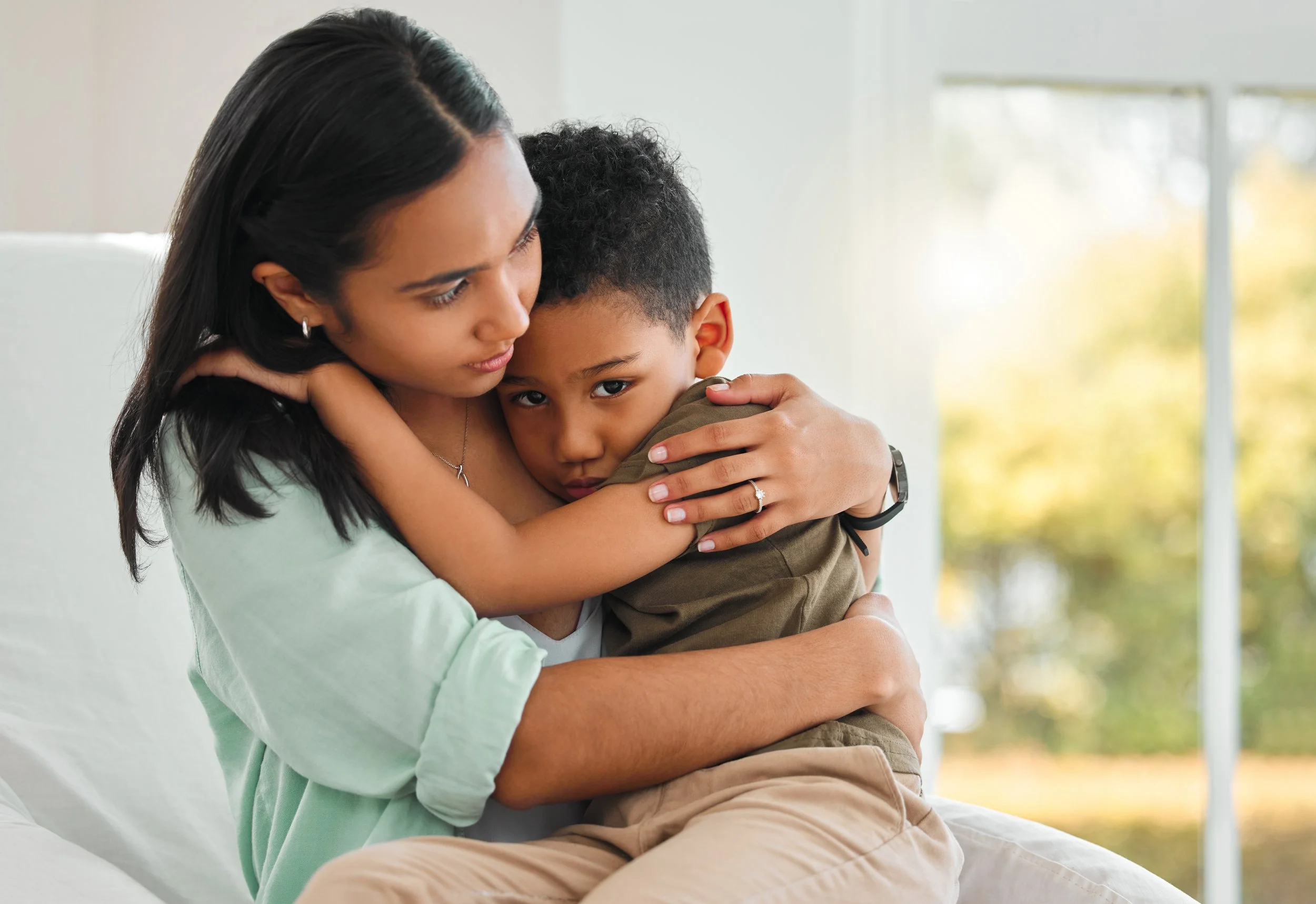 Mom comforting young boy who is sad.