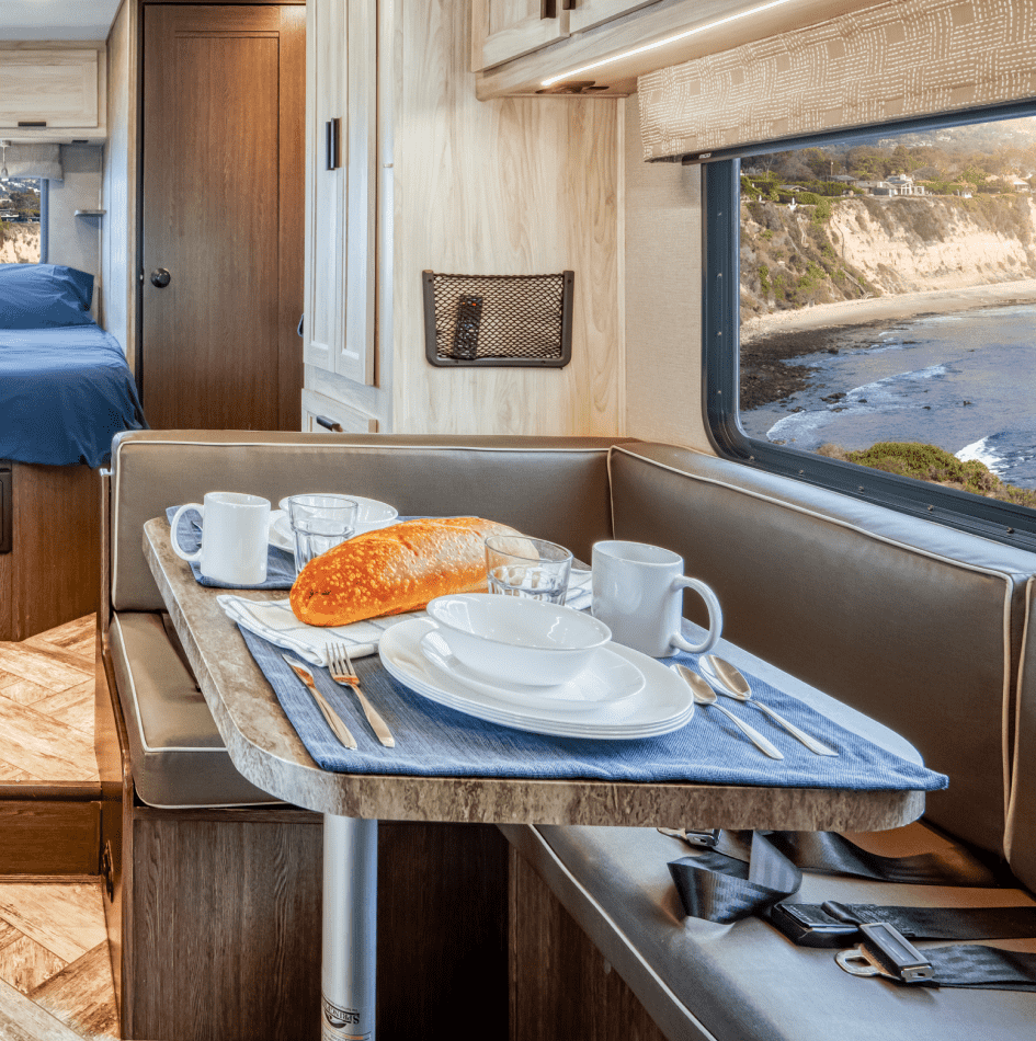 Desayuno en un comedor de autocaravana con vista al mar y acantilados